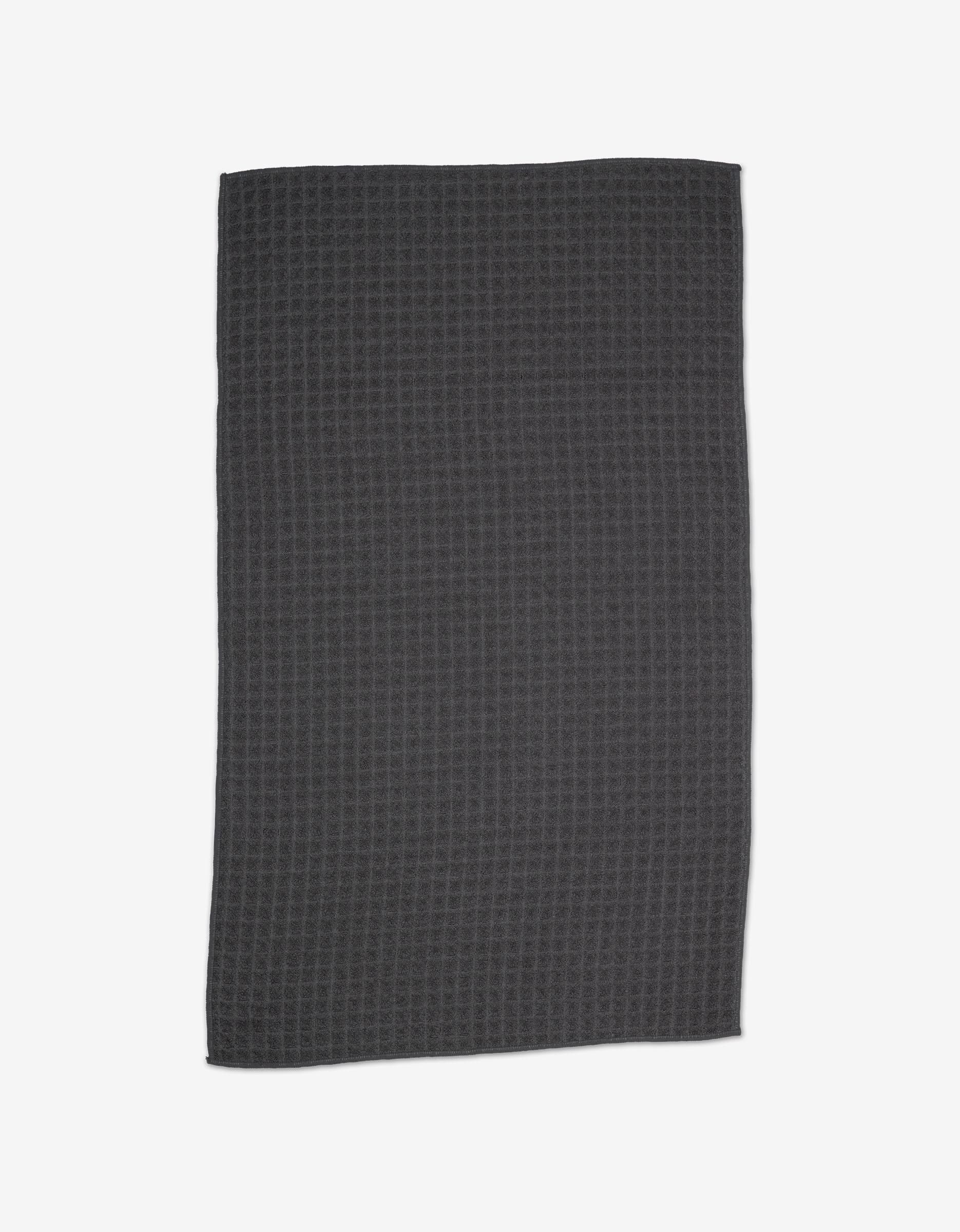 A GEOMETRY Charcoal Waffle Hand Towel in dark gray with a subtle texture is shown laid flat on a white background.