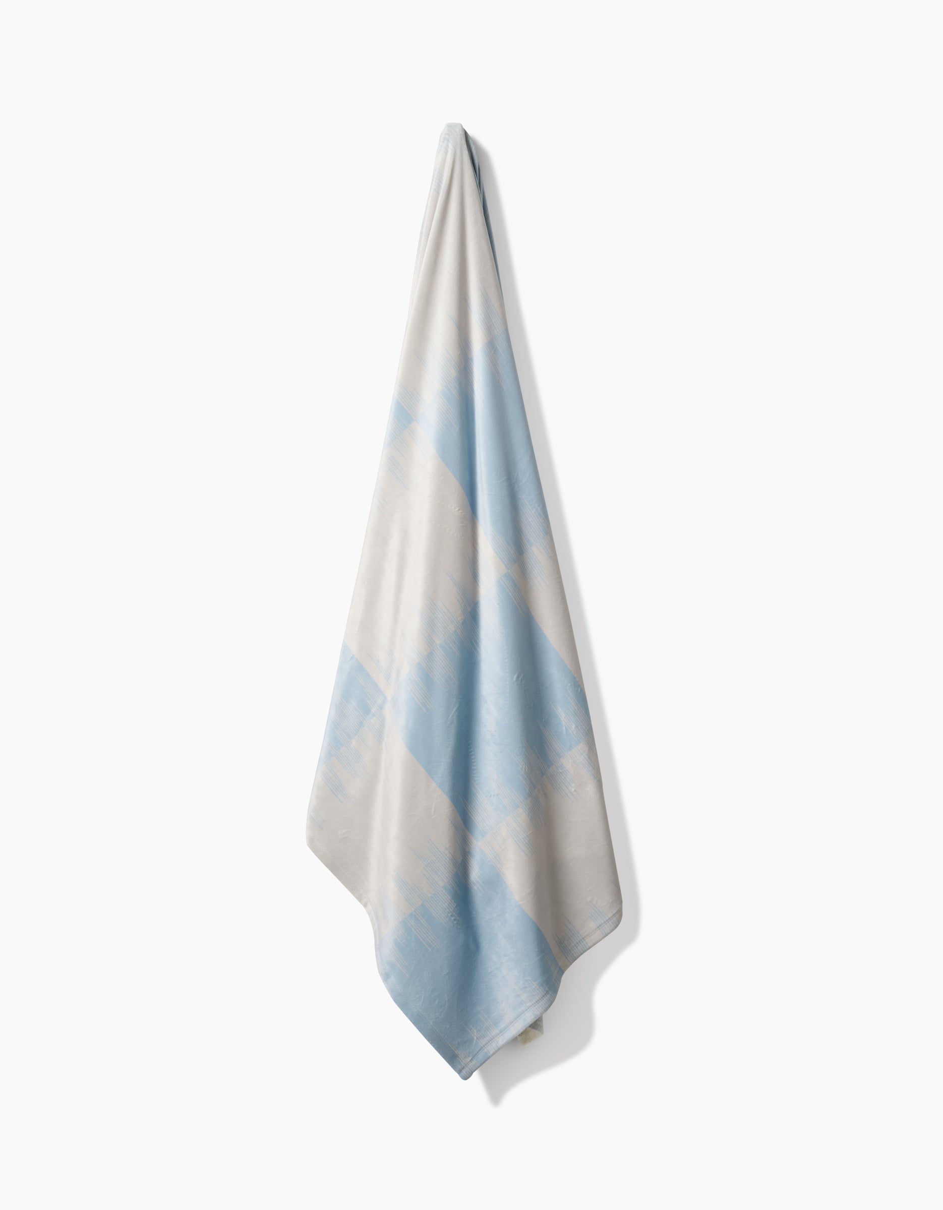 The Geometry Sweet Checks towel, made from recycled materials, features soft light blue and white diagonal stripes and is displayed against a plain white background.