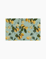 The Amalfi Lemons kitchen towel by Pascale Dilger is a rectangular, eco-friendly towel with yellow lemons, green leaves, and vines on a light blue dotted background.
