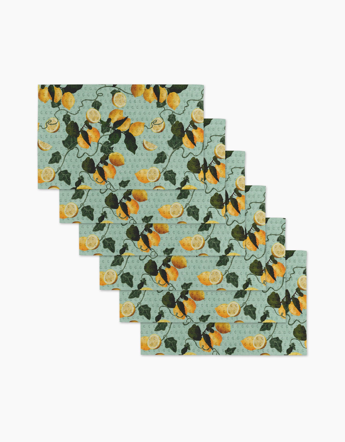 The Amalfi Lemons placemat set by Pascale Dilger includes six rectangular mats with a light blue-green background and a repeating lemon and green leaf pattern. Perfect for an eco-friendly kitchen, theyre neatly fanned in a stacked display.