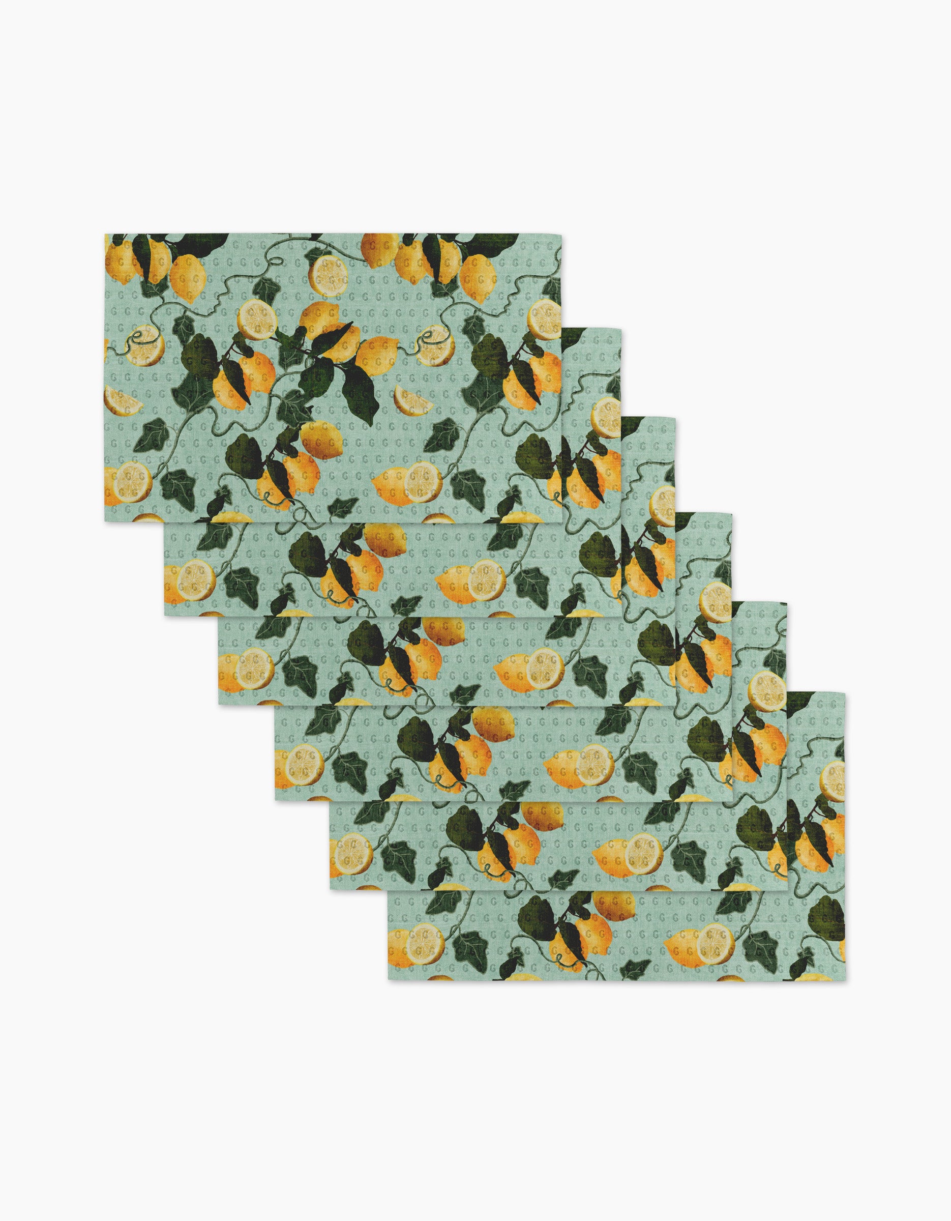 The Amalfi Lemons placemat set by Pascale Dilger includes six rectangular mats with a light blue-green background and a repeating lemon and green leaf pattern. Perfect for an eco-friendly kitchen, theyre neatly fanned in a stacked display.