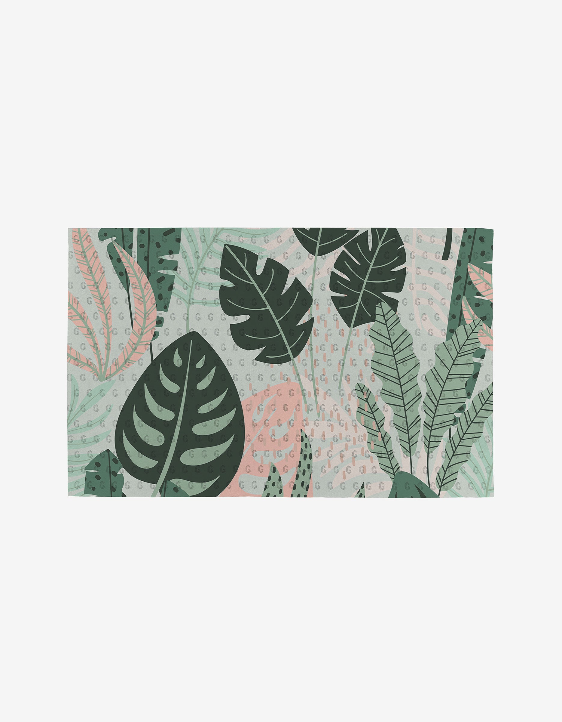 The GEOMETRY Artistic mat is rectangular, made from eco-friendly materials, and features large green tropical leaves with pink accents and small dotted details on a light background.