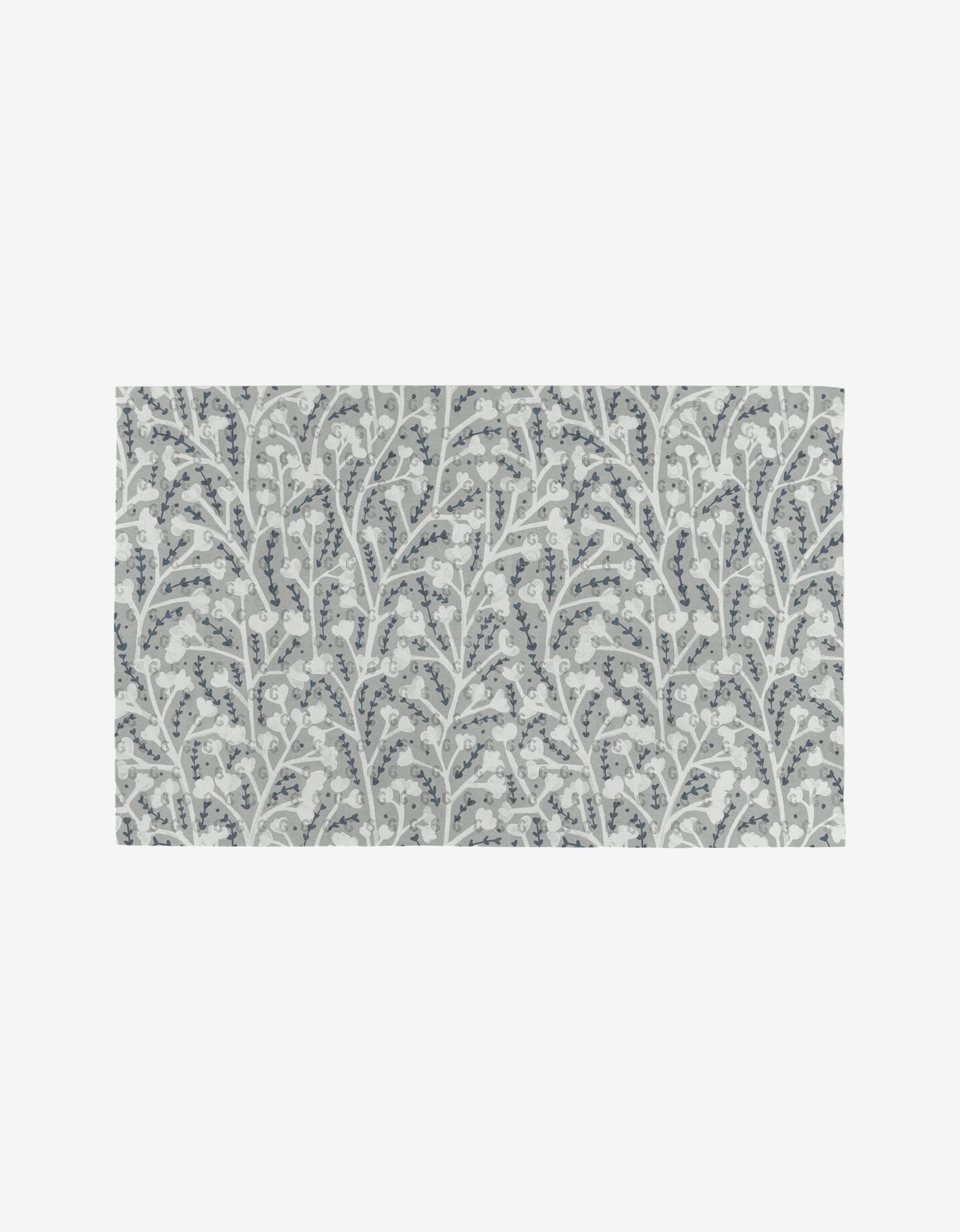 The Babys Breath rug by Katie OShea is a rectangular, reusable option with a repeating pattern of white flowers and leaves with light blue accents on gray—an eco-friendly alternative to paper towels.
