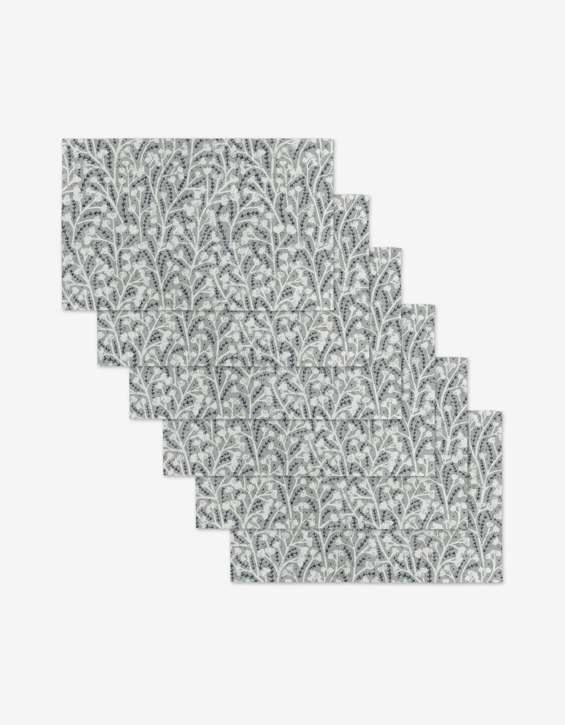 The Babys Breath placemats by Katie OShea include six reusable rectangular mats featuring a gray and white leafy branch pattern—an eco-friendly alternative to paper towels.