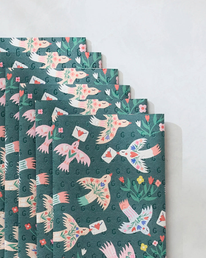 Birdsong Post by Ceyda Alasar features colorful birds carrying envelopes amid flowers and leaves on green—perfect inspiration for eco-friendly kitchen towels or recycled paper towel alternatives.