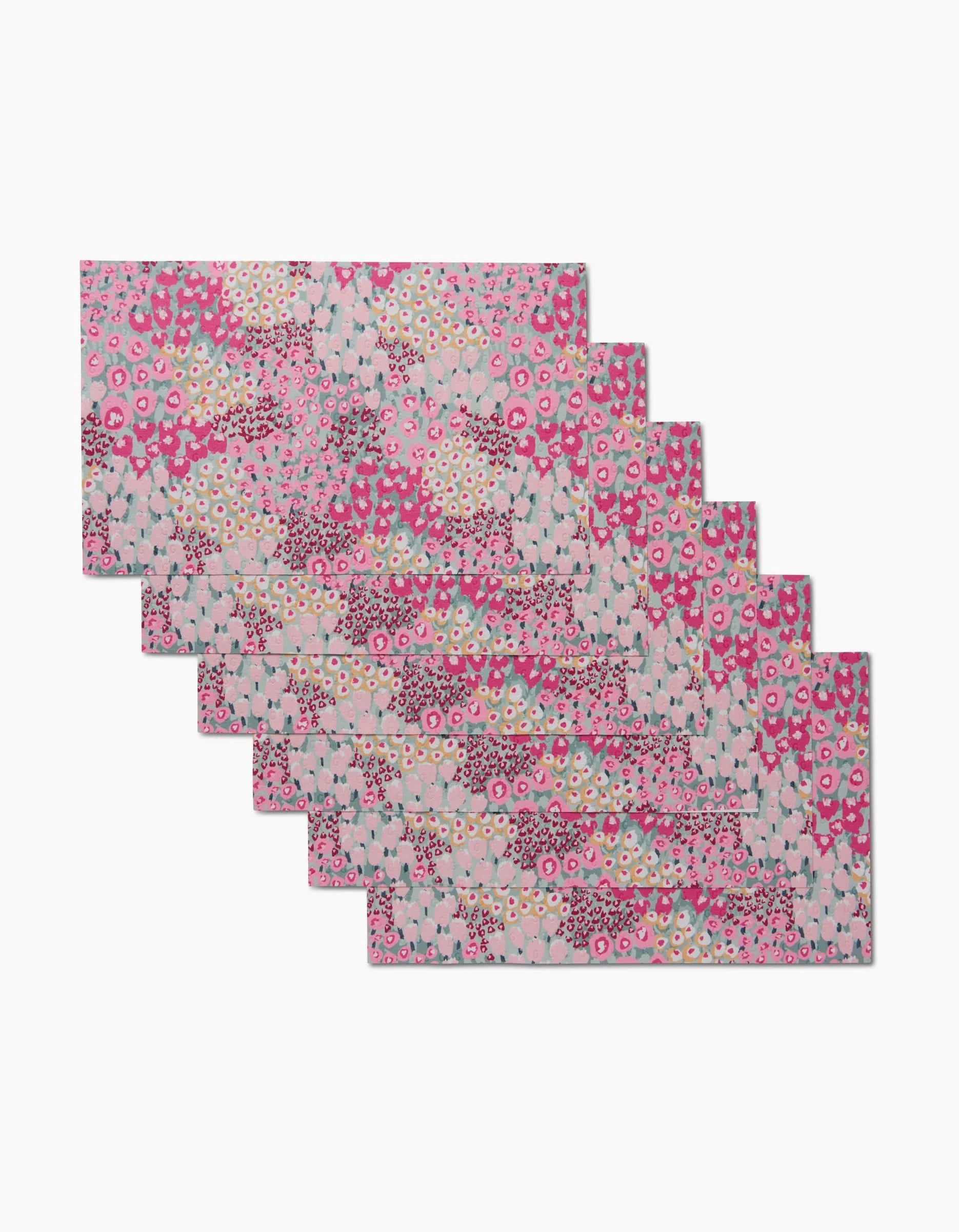 Eight Bloomed For Spring pink and white floral fabric napkins by Hufton Studio, an eco-friendly alternative to disposables, are stacked in a staggered arrangement on a white background.