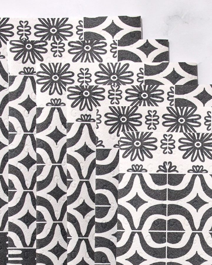 Bohemian Mosaic by GEOMETRY features overlapping rectangular tiles with black and white geometric and floral patterns, arranged in a stepped layout on a light background—perfect for stylish reusable paper towels.