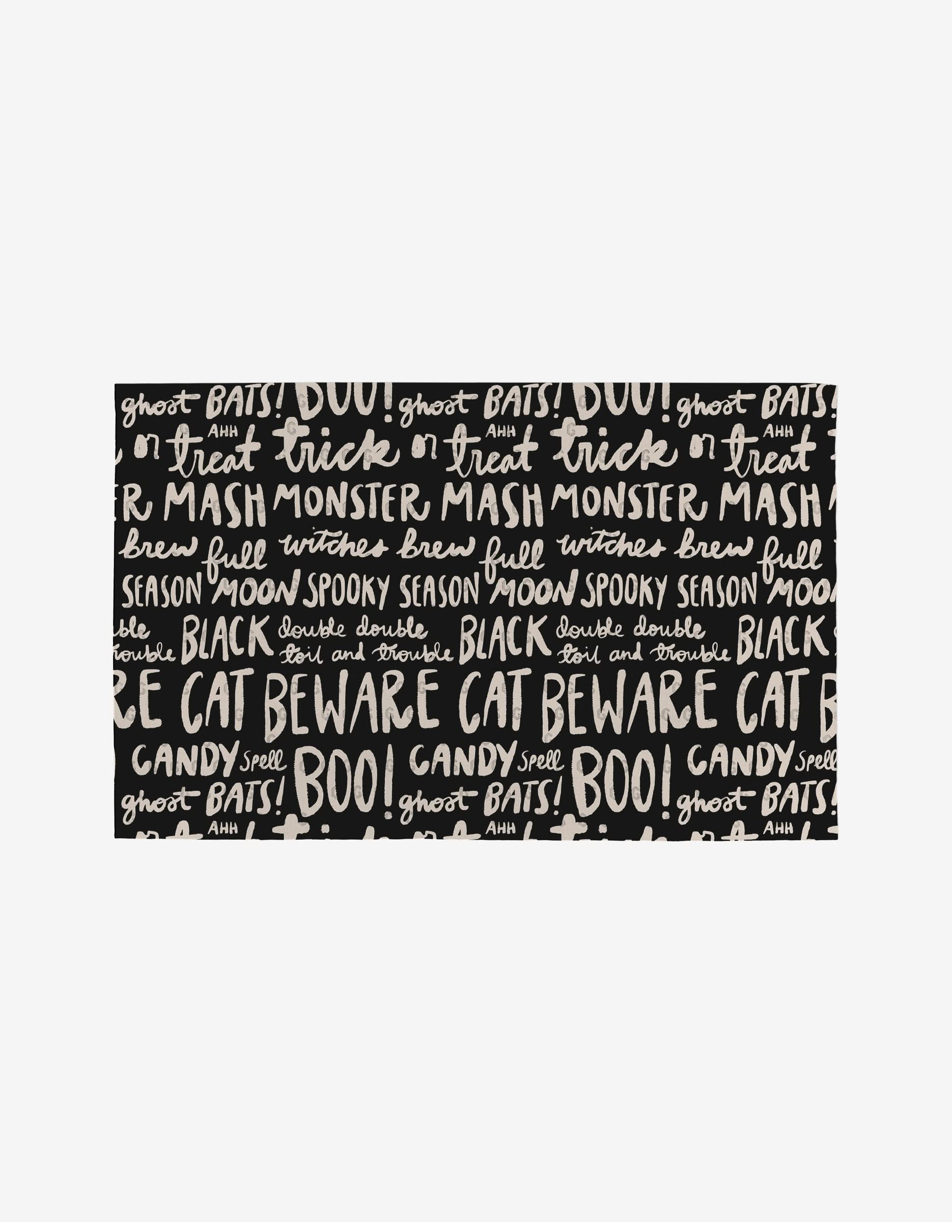 A black background with white hand-lettered Halloween words like trick or treat and monster mash decorates Booos by Kayla Ann—eco-friendly Not Paper Towels made from post-consumer recycled materials. Perfect for spooky season!.