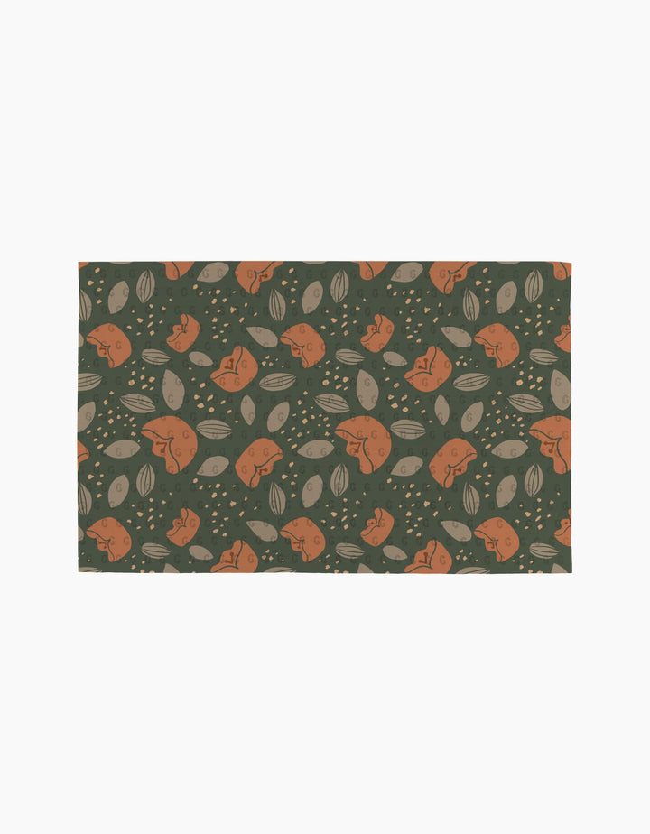 The Cali Sun mat by Amberleigh Adoff features orange rabbits, beige leaves, and dots on a dark green background for an eco-friendly touch inspired by reusable paper towels.