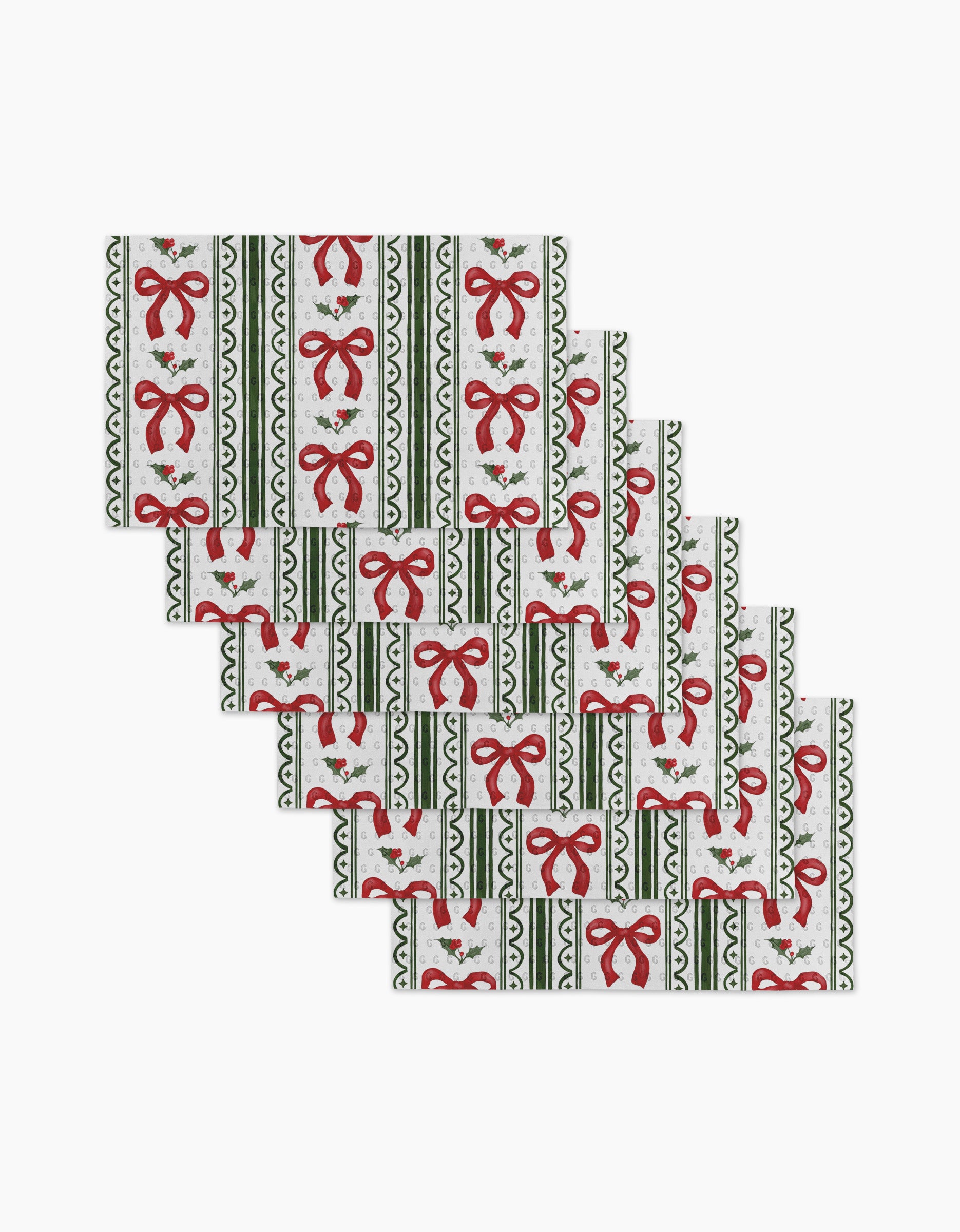 Set of eight Aubrey Fairchild Christmas Bow Stripe placemats, featuring red bows, holly, and green stripes on white—a festive and stylish alternative to eco-friendly paper towels for your holiday table.