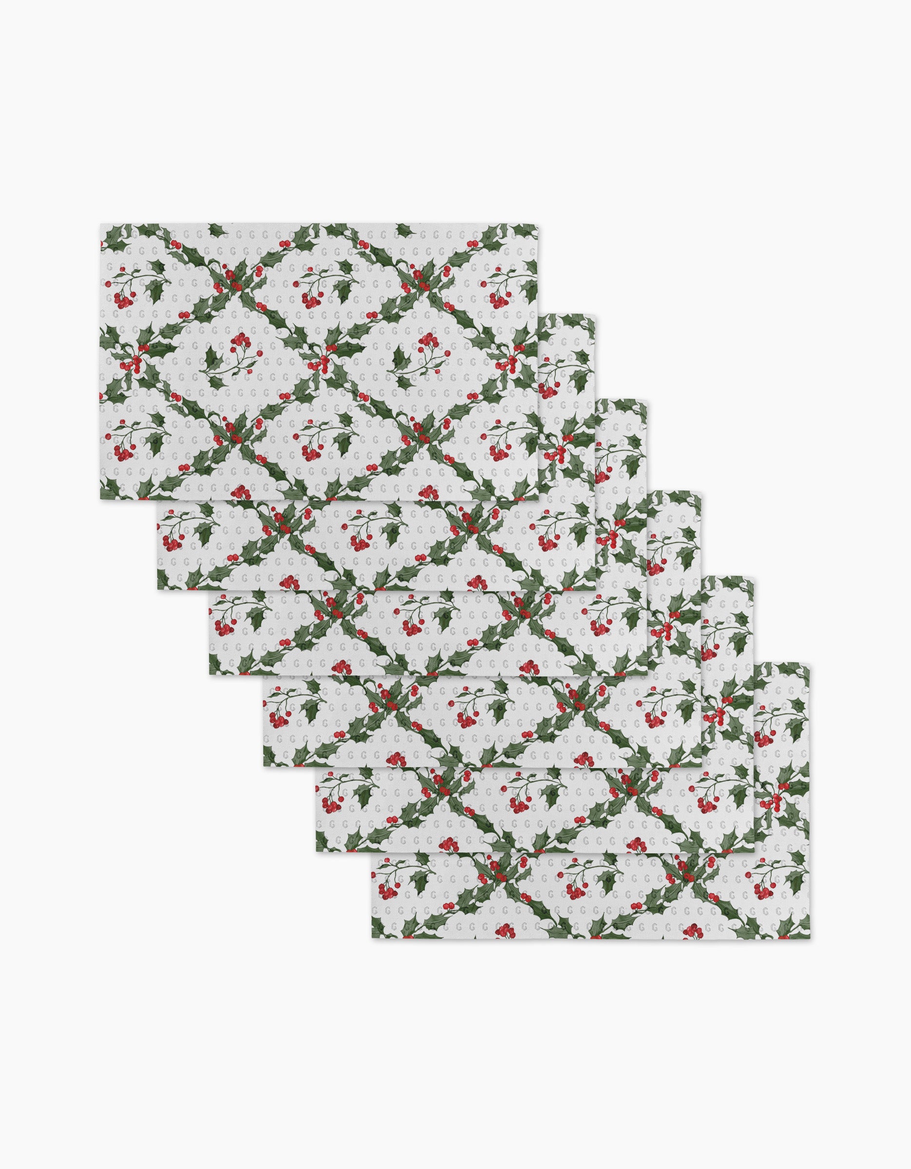 The Aubrey Fairchild Christmas Lattice set includes seven rectangular placemats featuring a festive holly and berry pattern—ideal for pairing with eco-friendly kitchen towels to create a sustainable holiday table.