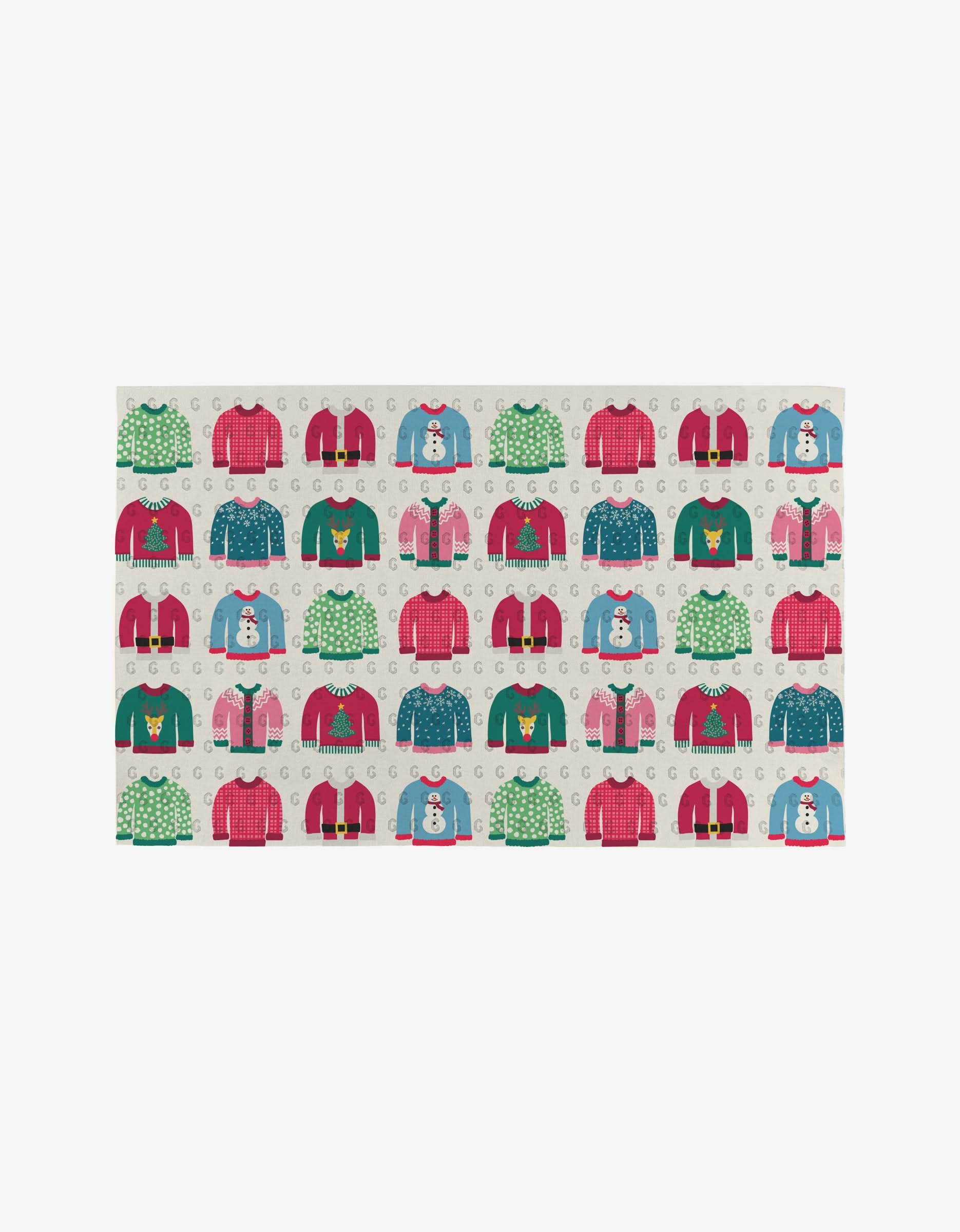 The Rebecca Bobko Christmas Sweaters mat is a reusable rectangular mat featuring a colorful holiday sweater pattern—red, green, blue, and pink, with snowmen and Christmas trees—set on a cream background with scattered letter Gs.