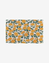 The Chrysanthemum by Vaishali Design Studio is a rectangular cloth made from post-consumer recycled materials, featuring a white background with a repeating pattern of bright yellow marigold flowers and green leaves.