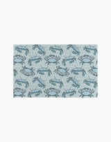 The Mindfulnice Coastal Crew mat features a repeating blue crab and bubble pattern on light gray, inspired by eco-friendly paper towels.