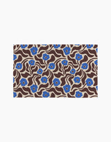 Coffee Reverie by Gerdadzy is a rectangular rug featuring wavy brown lines and blue flowers with beige centers on a beige background, ideal for enhancing eco-friendly kitchens or pairing with sustainable towels.