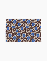 Coffee Reverie by Gerdadzy is a rectangular rug featuring wavy brown lines and blue flowers with beige centers on a beige background, ideal for enhancing eco-friendly kitchens or pairing with sustainable towels.