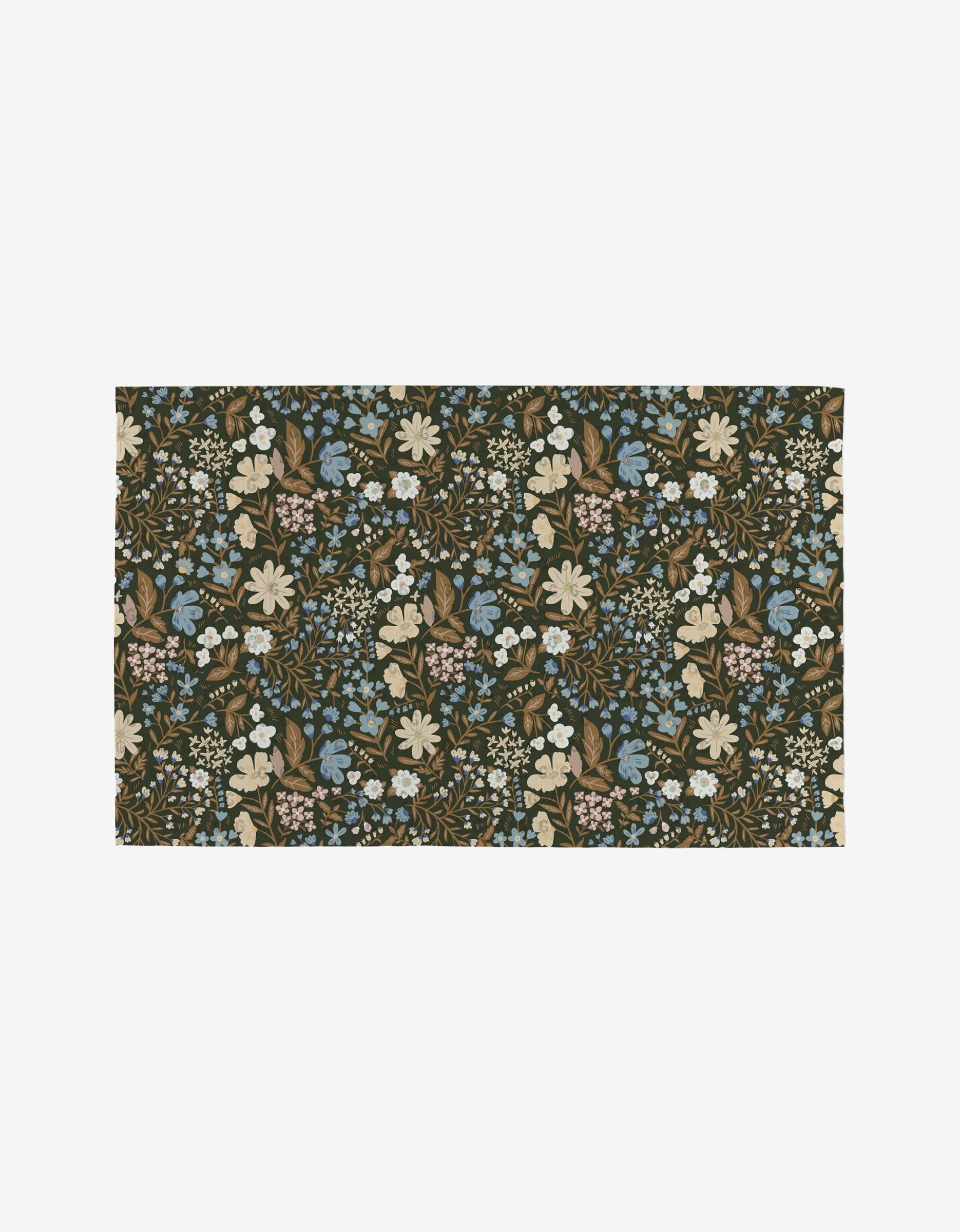 The Danelys Sidron Cottage Meadow Sepia is a reusable rectangular rug with an intricate floral pattern of blue, cream, pink, and white flowers plus green and brown leaves on a dark background.