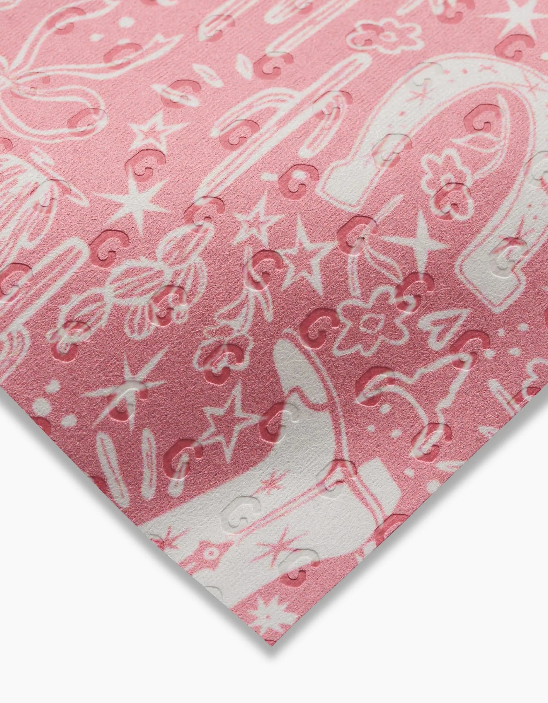 A close-up of Aubrey Fairchild’s Cowgirl Chic: a pink, eco-friendly fabric with white western prints—cowboy boots, horseshoes, cacti, stars, flowers—and an embossed swirl pattern; perfect for reusable Not Paper Towels.