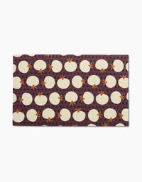 Add vibrant color to your kitchen with the Dancing Fall mat by Lizzie Clark, featuring white eggs, orange chicken feet, and small G letters on a dark purple background—perfect for pairing with reusable paper towels.
