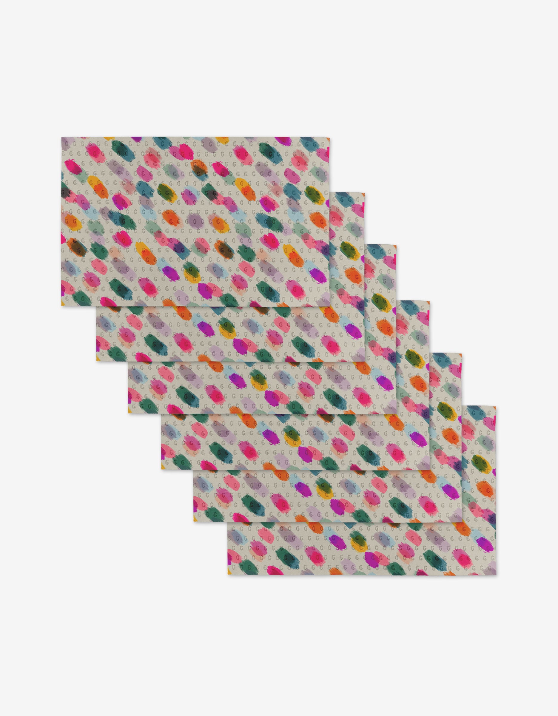 Six colorful rectangular cloth napkins from GEOMETRY’s Downpour collection overlap in a staggered arrangement. Made from post-consumer recycled materials, each features multicolored brushstroke dots—an eco-friendly choice.