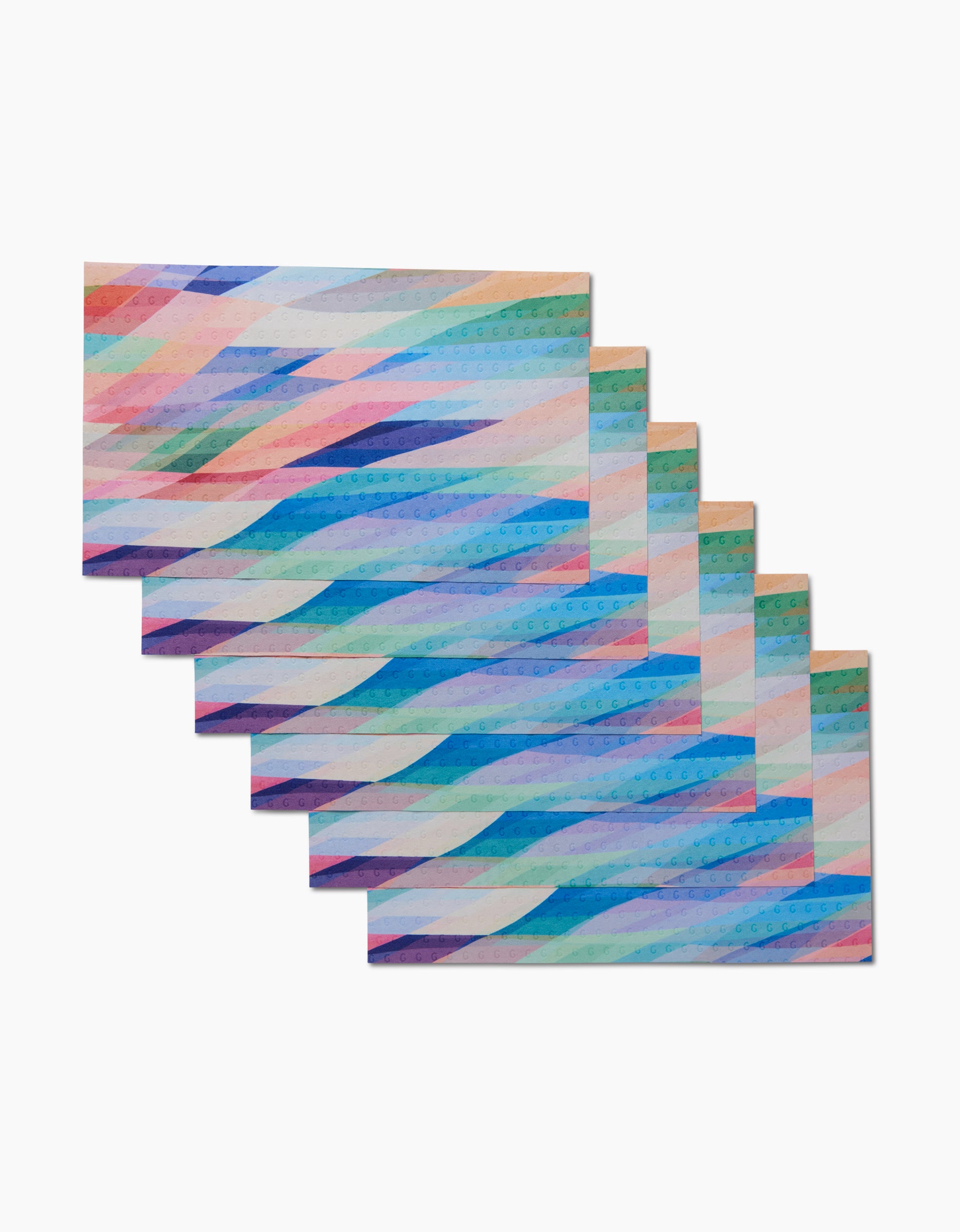 Six rectangular cards from Rachel Parkers Eventide collection feature pastel geometric diagonal patterns, arranged in a step-like stack on white. The eco-friendly designs are inspired by reusable paper towels and recycled materials.