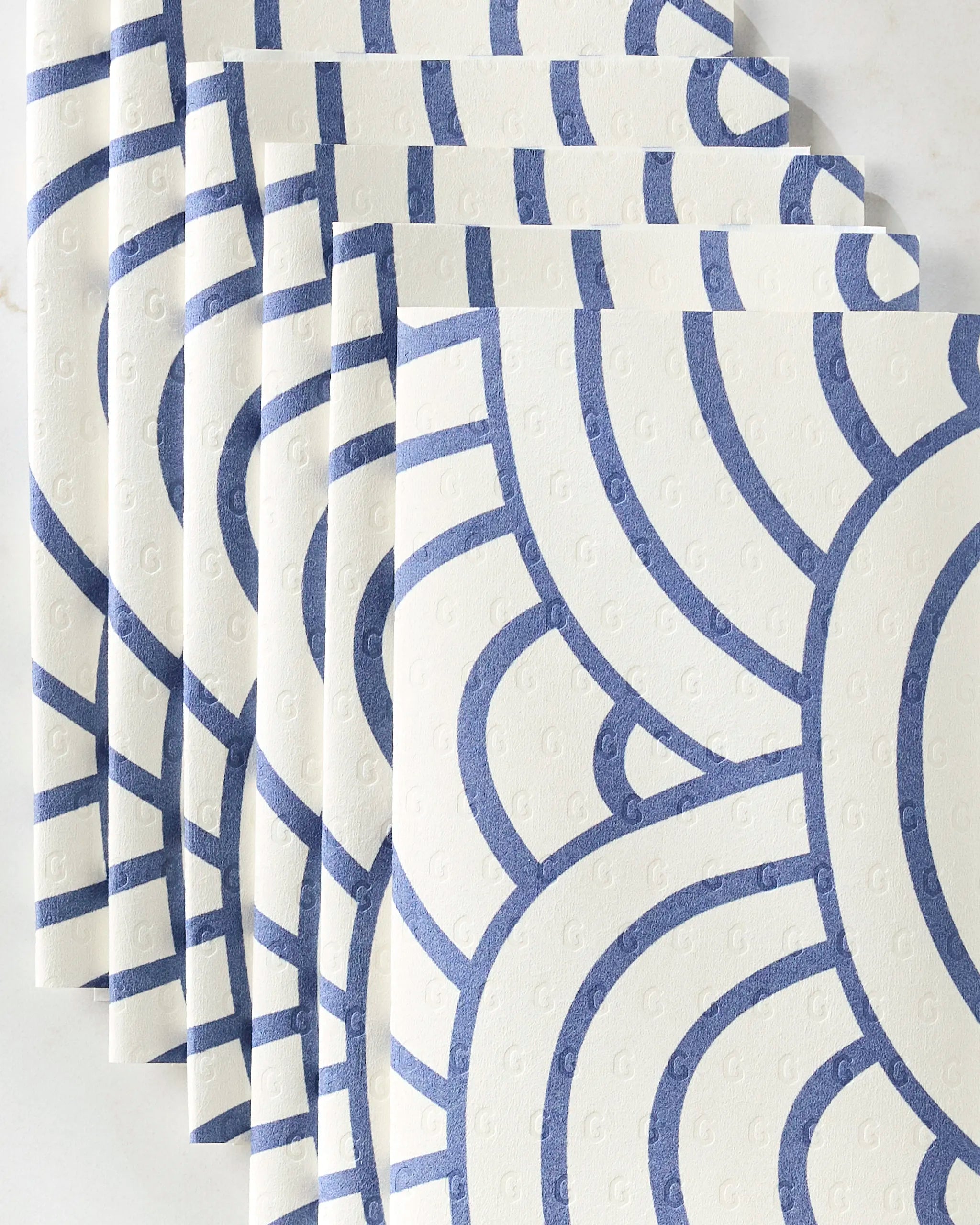 Every Level by GEOMETRY features white reusable paper towels with blue geometric lines, displayed in a fan shape on a white surface.