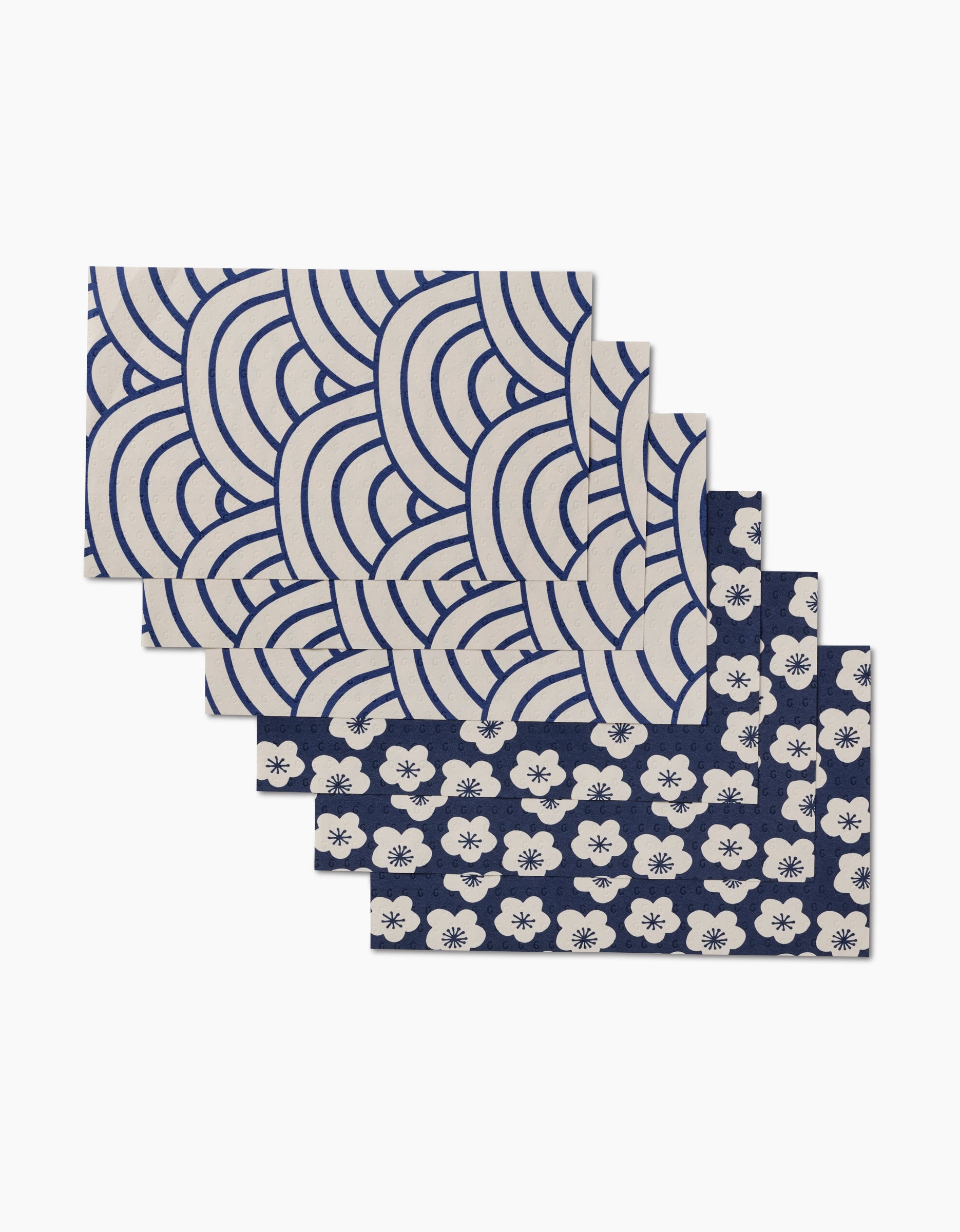 Five rectangular Every Wish reusable cloth napkins by GEOMETRY are displayed in a fanned stack—three with blue and white wave designs, two with blue and white floral patterns—a stylish, eco-friendly option.