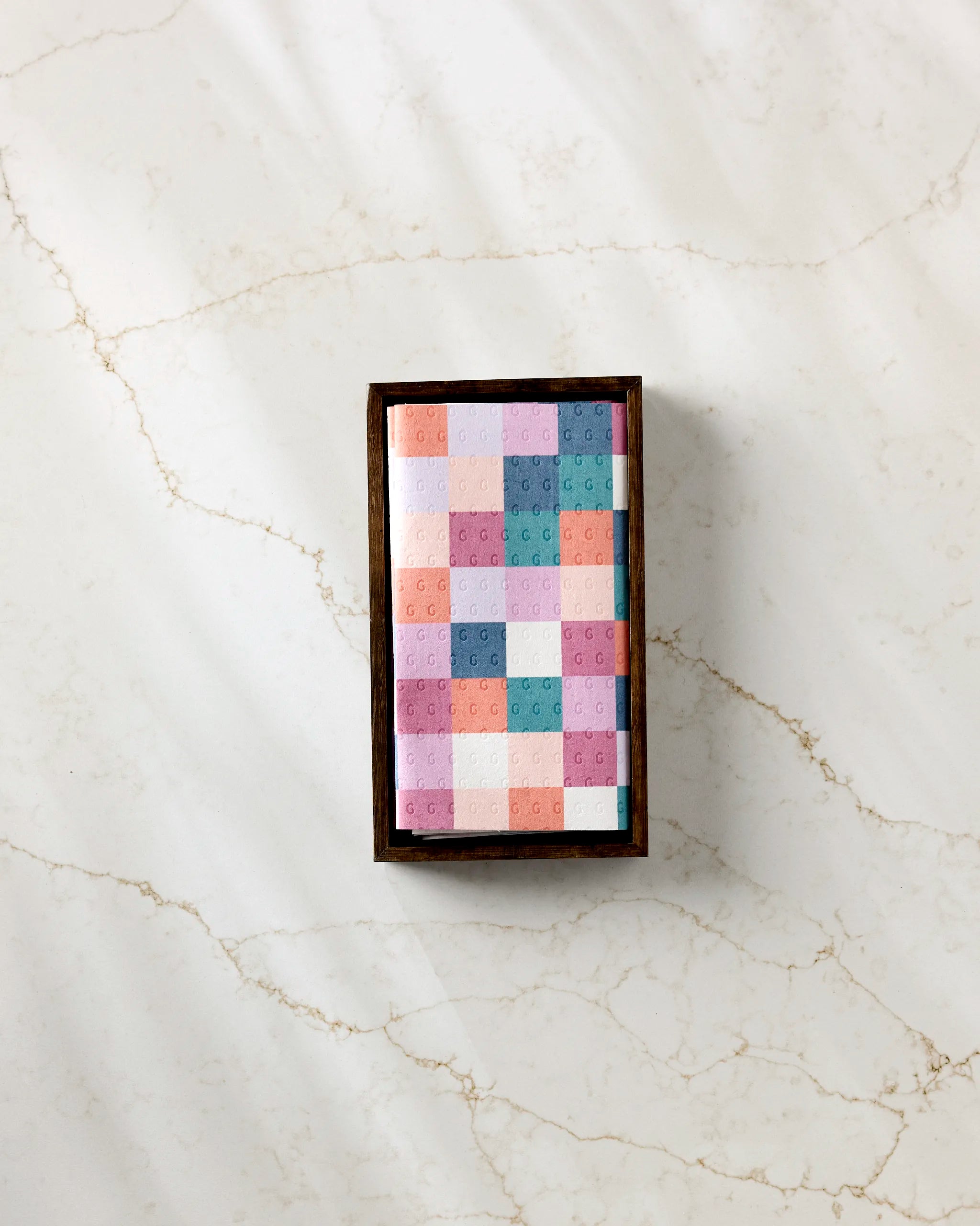 The Claire Iglesias Fall Checkers box features a colorful geometric pastel lid and sits on light marble, offering a stylish, eco-friendly way to store reusable paper towels as an alternative to disposables.