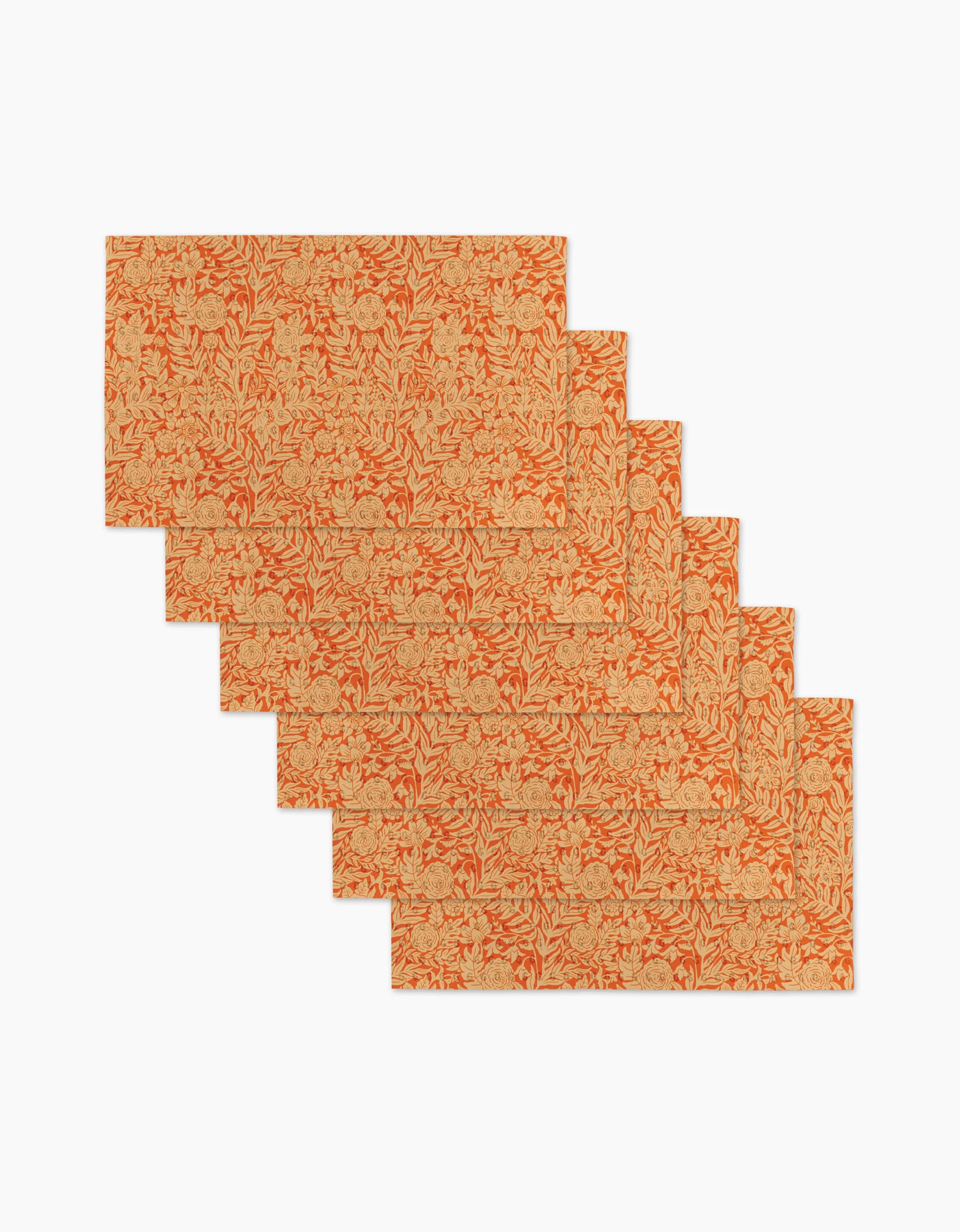Six Florence rectangular placemats by Katie OShea, featuring an orange and beige floral pattern, are stylishly arranged in a staggered, overlapping layout on a white background.