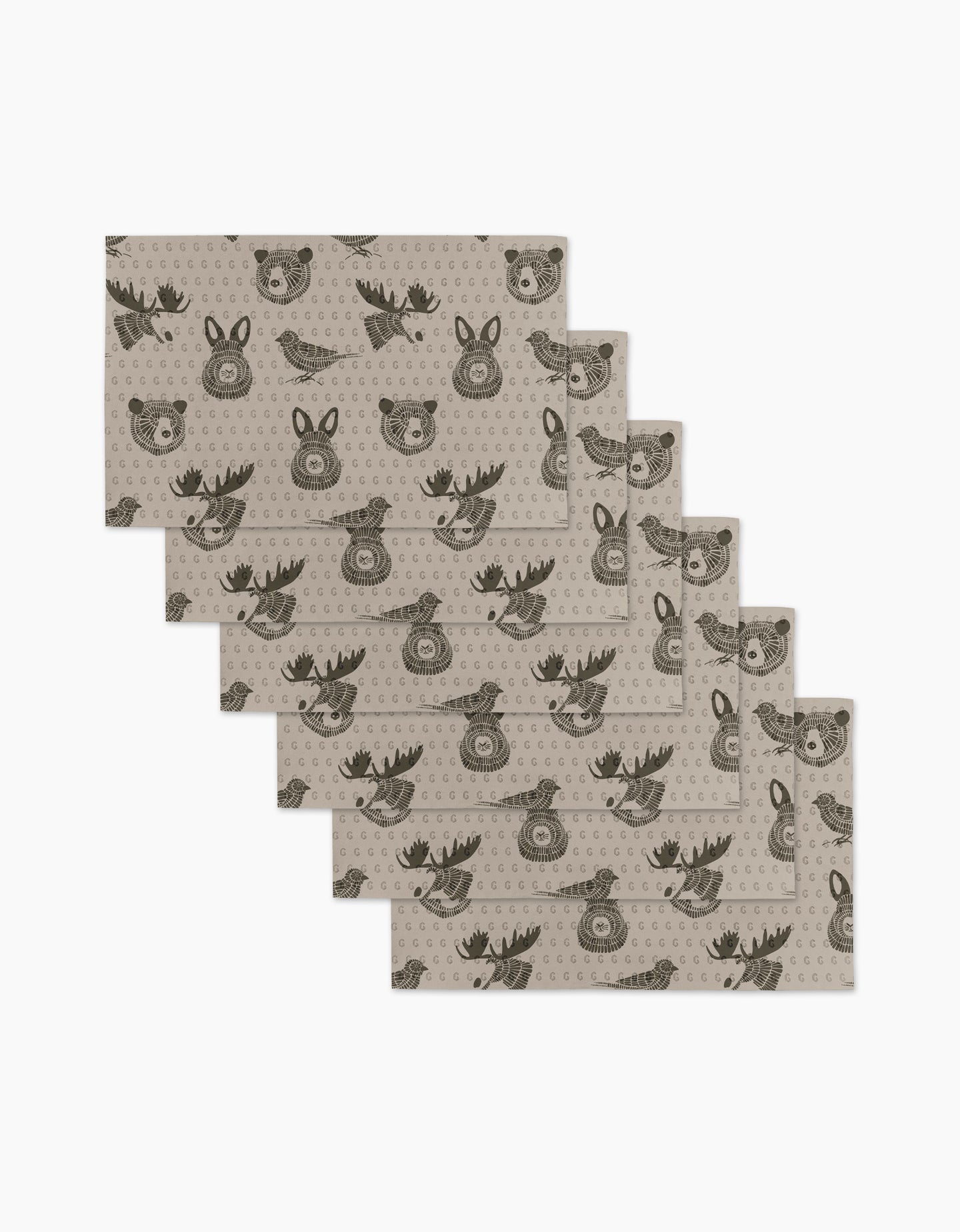 Six beige Forest Animals placemats by Rosa Kichline feature repeating cartoon faces of a bear, deer, and fox in dark brown. These eco-friendly kitchen towels are arranged in a slightly fanned-out stack.