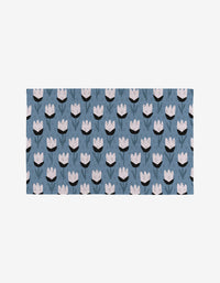 Forest Findings by Anette Heiberg is a rectangular fabric featuring stylized light pink tulips and dark green stems on a muted blue background—a sustainable, eco-friendly option thats not paper towels. Perfect for greener living.