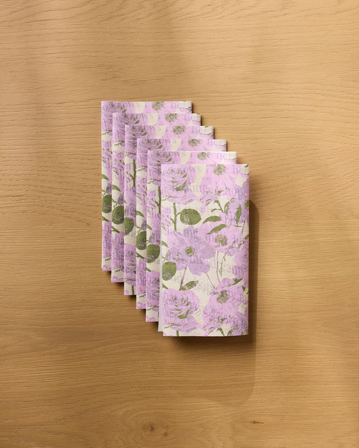 Geometry's "Forever Mom" stack features pink floral and green leaf patterned papers, echoing eco-friendly kitchen towels, neatly arranged on a light wooden surface.