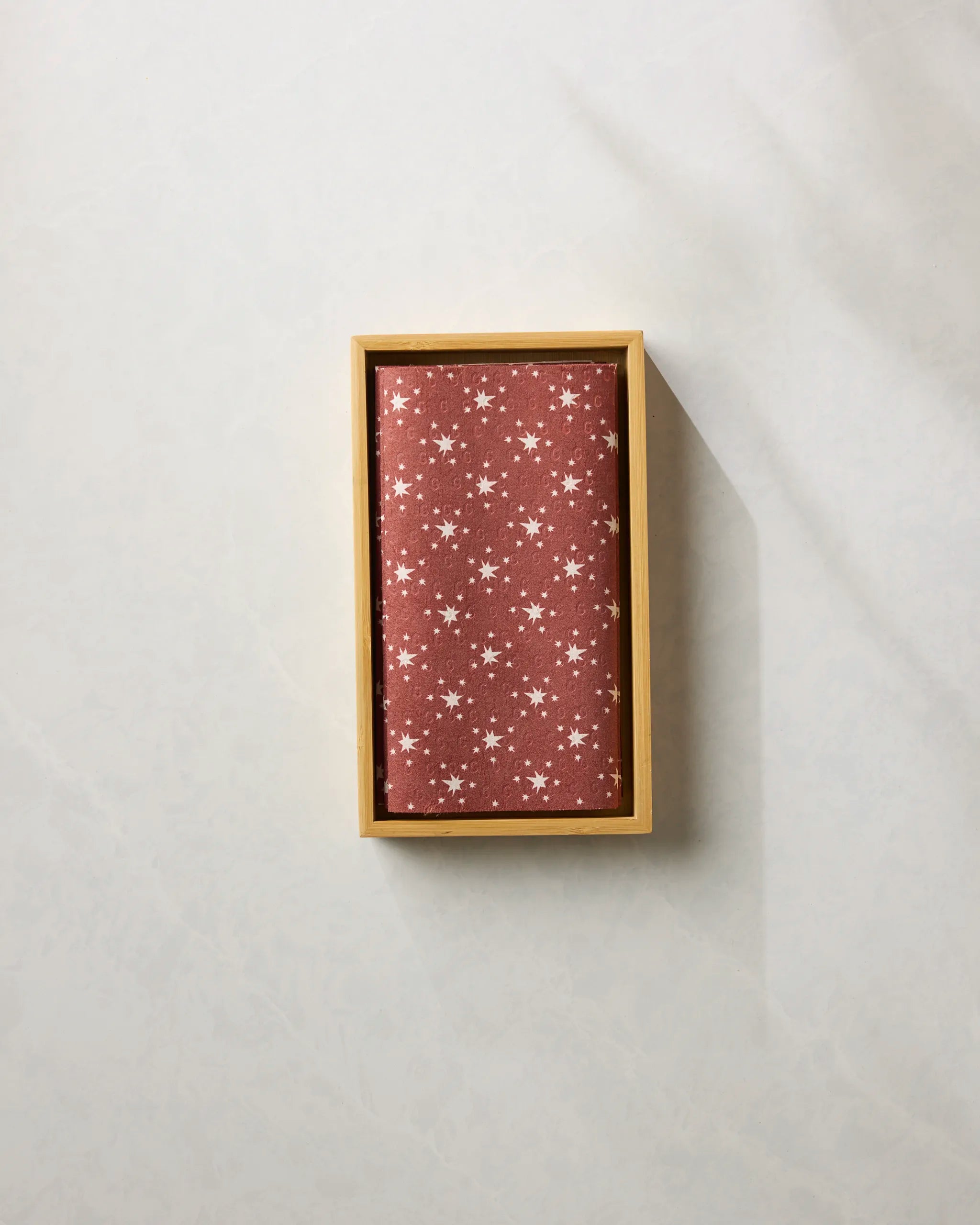 The Geometry Freedom Red is a rectangular box with a brown cover featuring white stars, designed to store eco-friendly paper towels and displayed on a light surface.