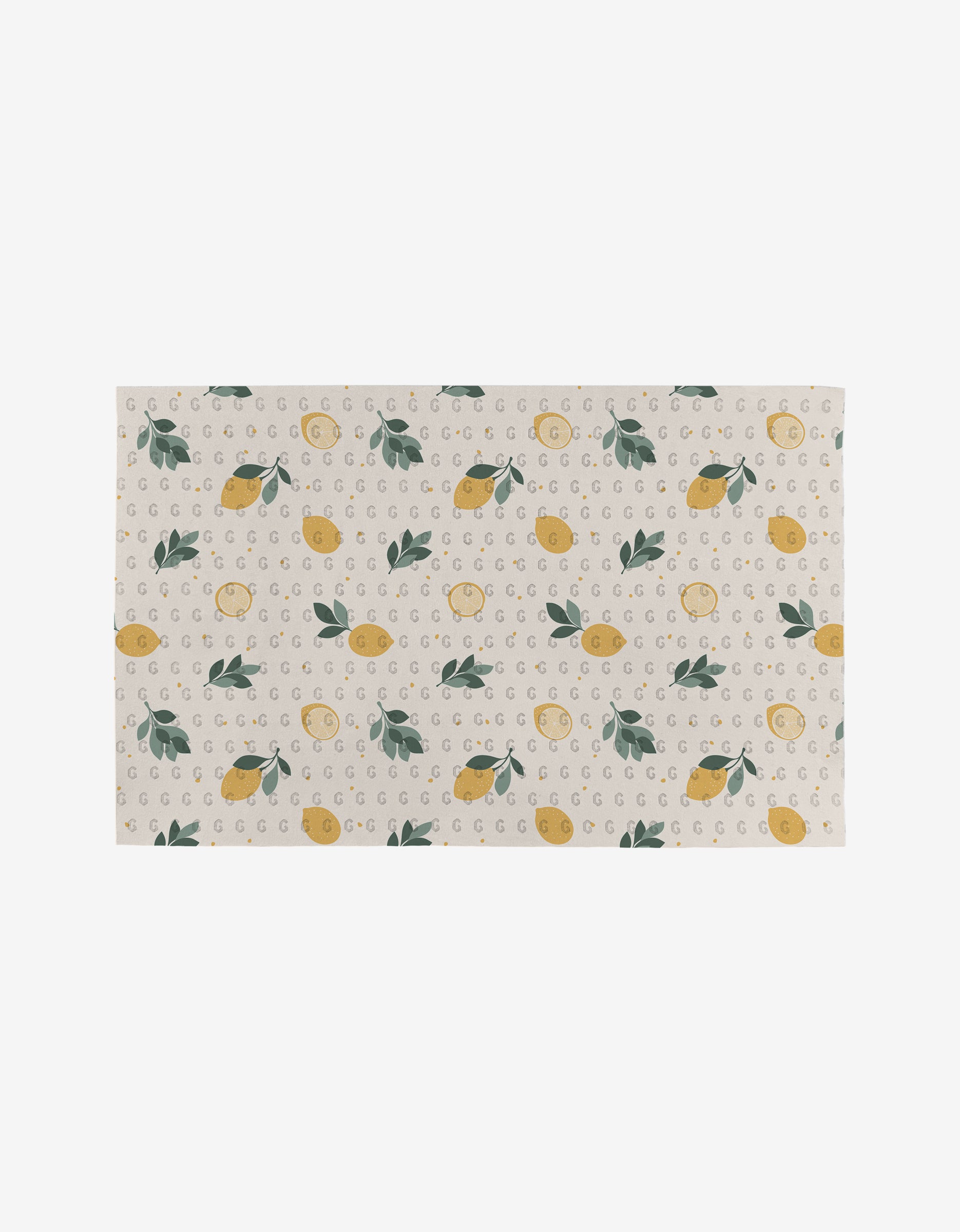 The Sara Mari Freshly Picked mat features a rectangular beige design with yellow lemons, green leaves, and gray Gs on a light background—crafted from recycled materials for an eco-friendly touch.