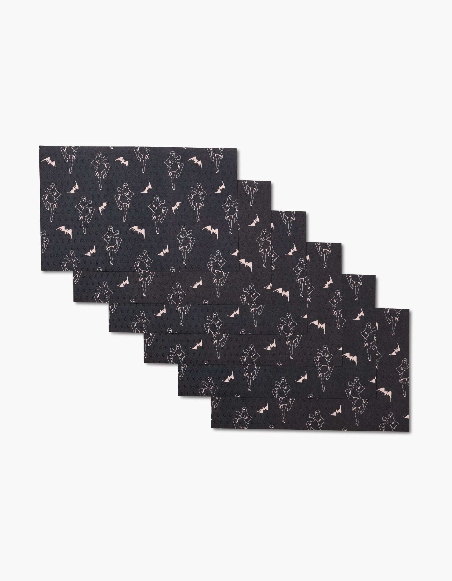 Six rectangular black Ghost Pin Up placemats by Cole Strem are stacked in a staggered pile. Each reusable placemat features a white outline pattern of bats and vampire-like figures on a plain white background.