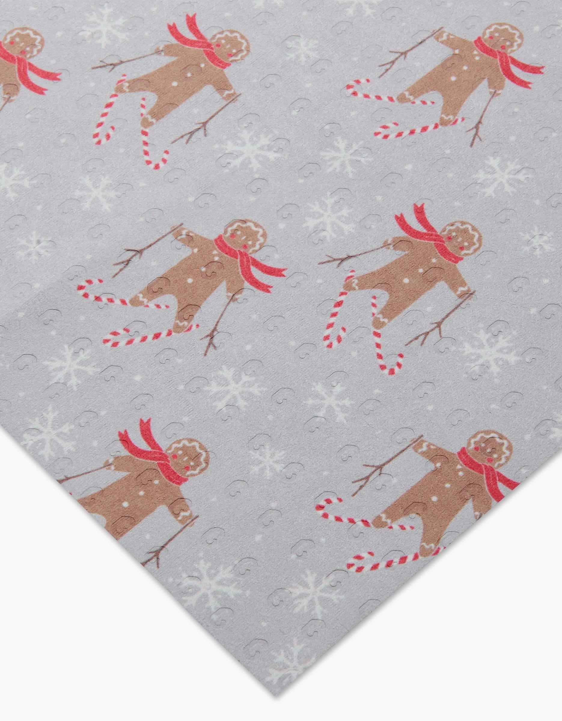 Gingerbread Land by Roxy Marj features gray wrapping paper with playful gingerbread people in red scarves, candy canes, and snowflakes. Pair with eco-friendly paper towels for a sustainable holiday celebration.