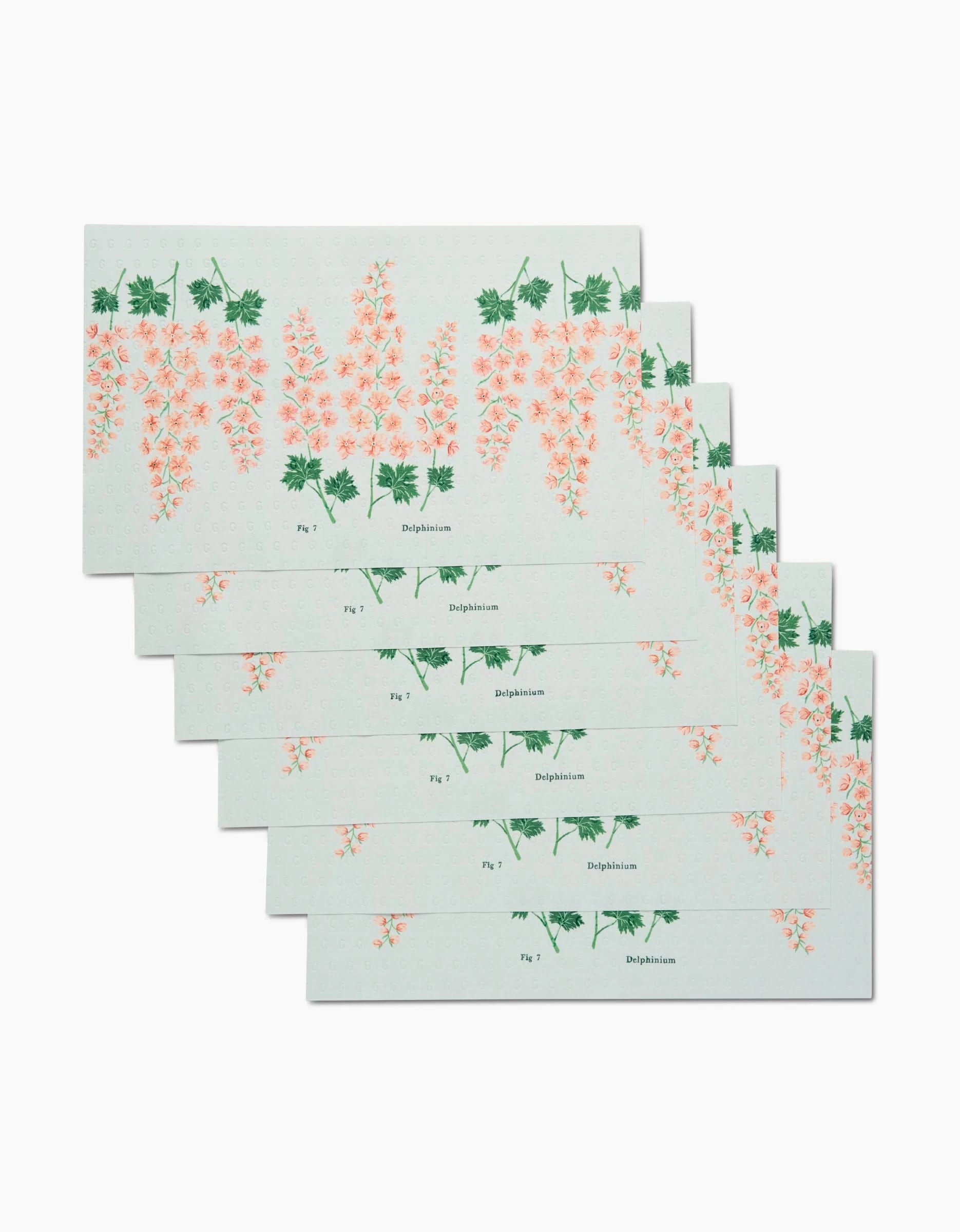 Six rectangular July Delphinium cards by Linda Fox are arranged in a stepped stack, each made from eco-friendly materials and featuring a botanical illustration of pink Delphinium flowers with green leaves and labeled “Delphinium.”.