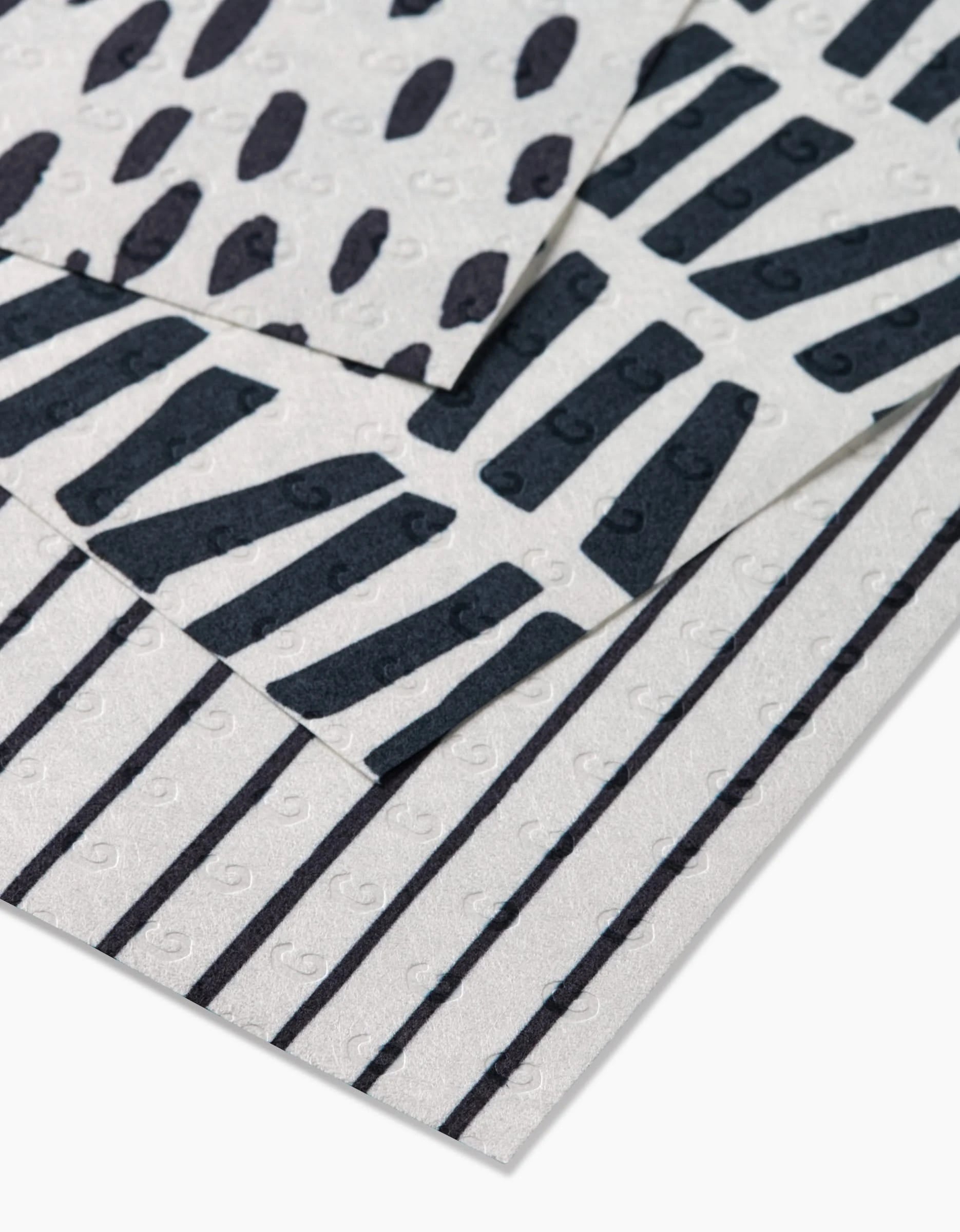 Three Lines, Dots and Dashes sheets by GEOMETRY feature black dots, diagonal lines, and vertical stripes on subtly swirled white backgrounds. Made from eco-friendly post-consumer recycled materials.
