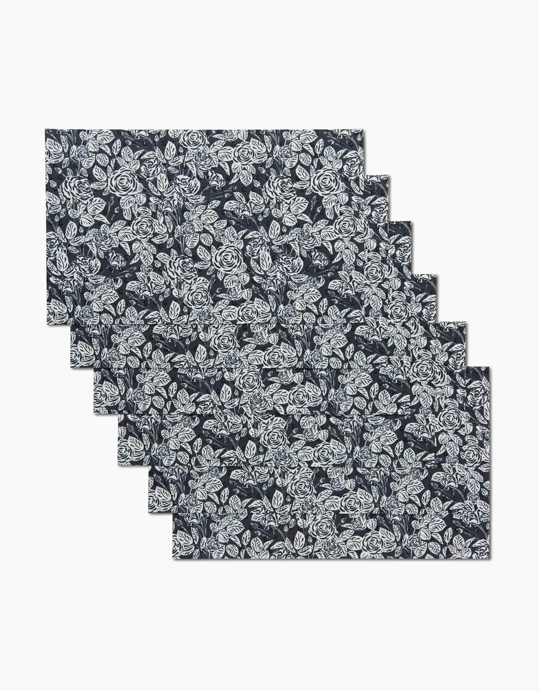 Six Love and Roses Onyx reusable paper towels by Charlie Rowan Designs, each dark-colored with a white floral pattern, are neatly stacked and slightly offset on a plain white background.