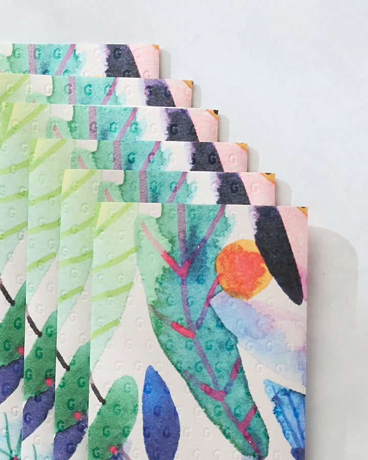 Five “Morning” notebooks by Maria Montiel, featuring colorful abstract watercolor leaf patterns with a red-orange circle. Perfect for fans of sustainable stationery or those inspired by eco-friendly paper designs.