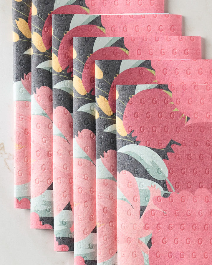 Six pink and gray "My Garden" reusable paper towels by GEOMETRY, featuring floral designs and a subtle embossed G pattern, are neatly stacked with slight overlap on a light surface.