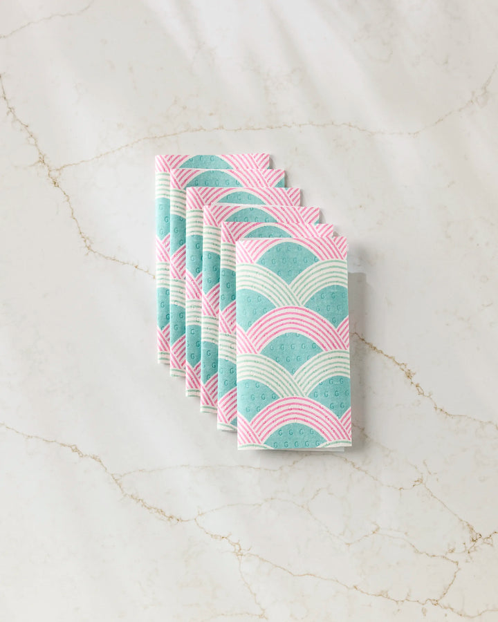 Six Nalin reusable paper towels by Amy MacCready, featuring a pastel arch pattern in pink, teal, and white, are neatly folded and set on a light marble surface.
