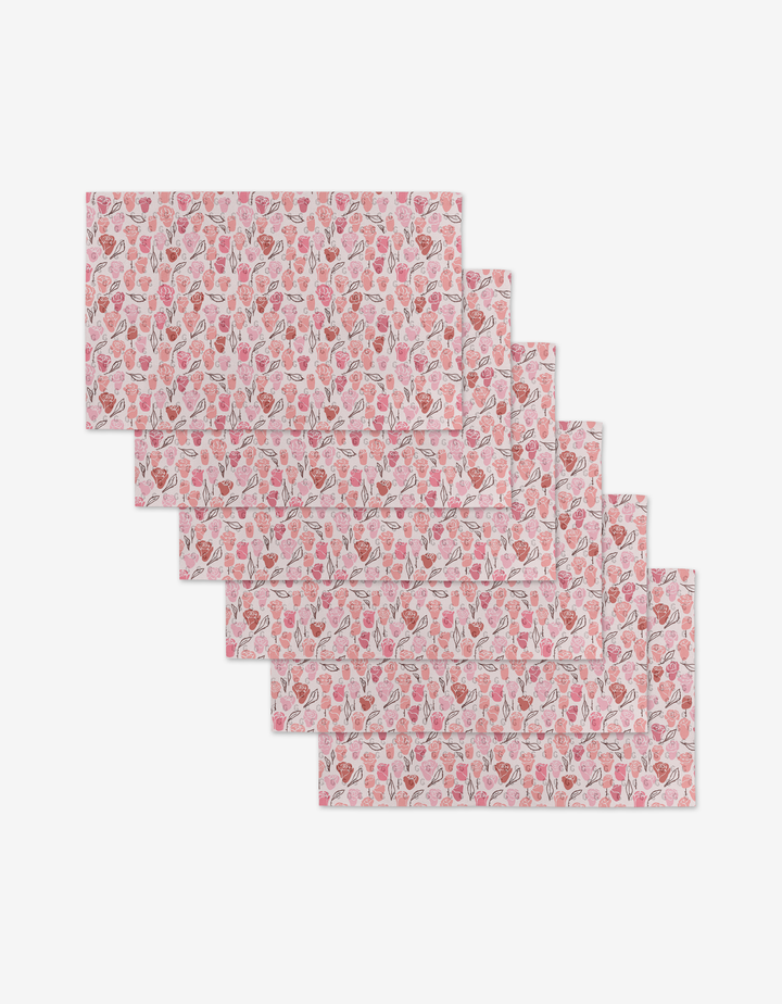 Six reusable rectangular placemats from Elisabeth Wing, in the Neutral Rose design featuring a pink and white strawberry pattern, are stacked on a white background—an eco-friendly alternative to Not Paper Towels.