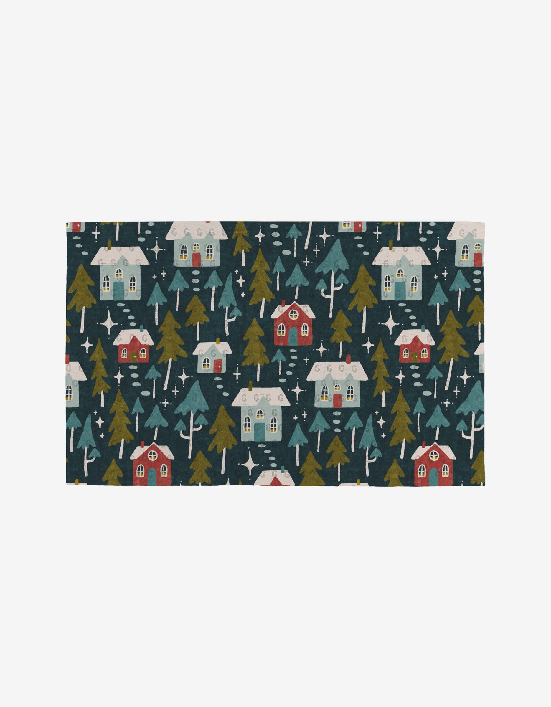 The Nico Dark by Amy MacCready is a rectangular, eco-friendly towel made from recycled materials. It features snowy houses, pine trees, and stars in green, red, white, and yellow on a dark blue background for a cozy winter village feel.