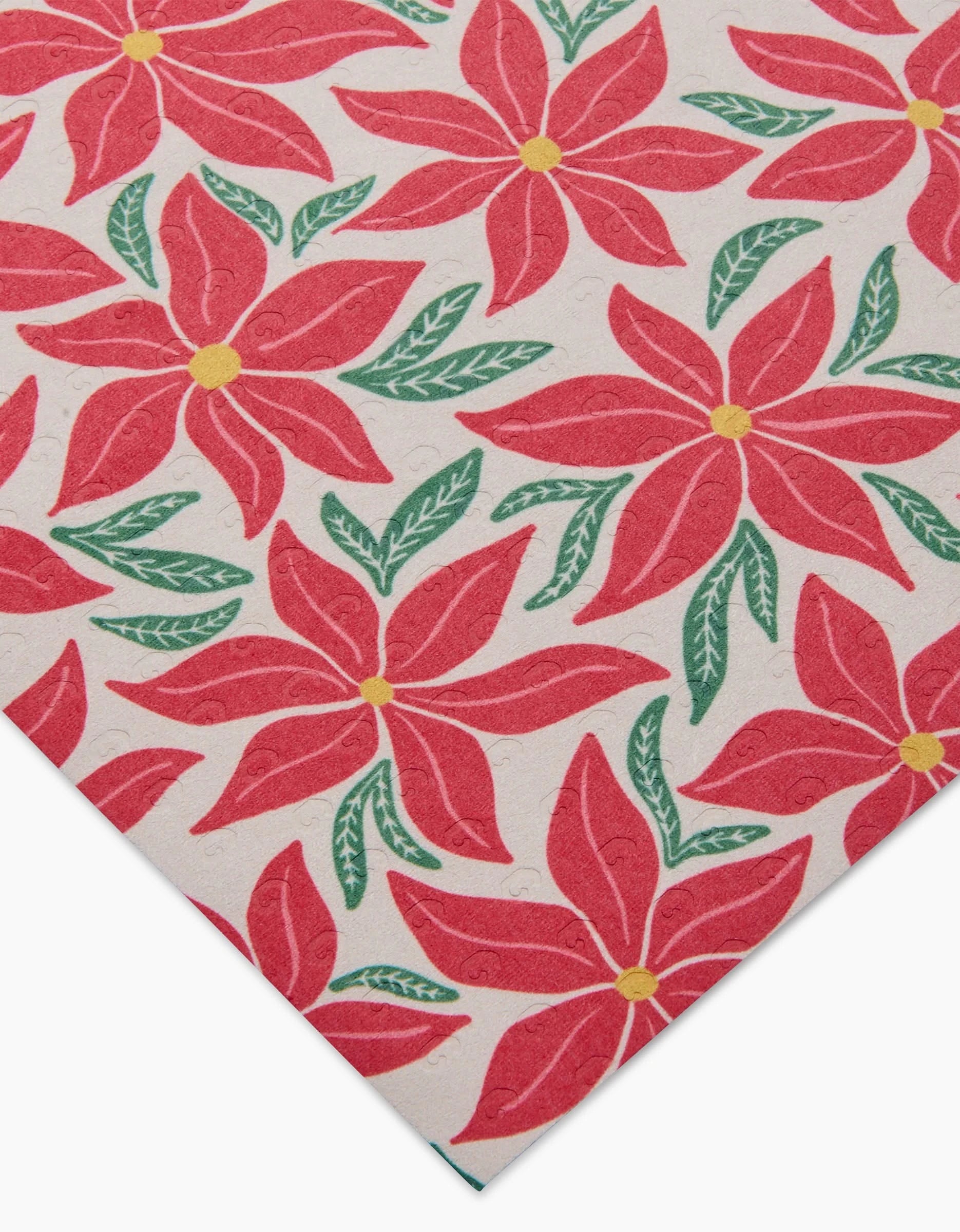 Poinsettia Party by Kayla Ann features red poinsettias with yellow centers and green leaves on a light background. Shown close up at an angle, this machine-washable design is ideal for reusable paper towels.