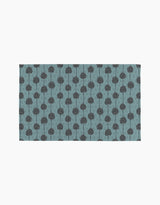 Polka Dot Blooms by Lizzie Clark is a rectangular mat featuring evenly spaced, simple black stylized trees on a muted blue background. This minimalist design brings eco-friendly, sustainable style to any space.