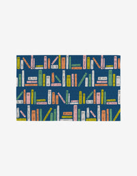 The School Days rug by Amy MacCready features pastel-colored books on a dark blue background, crafted from eco-friendly, post-consumer recycled materials.
