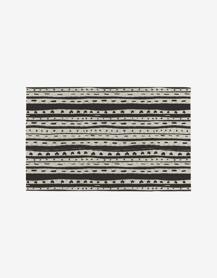 The Self Love rug by Danelys Sidron features hand-drawn black and white horizontal stripes with geometric patterns on a white background, crafted from eco-friendly post-consumer recycled materials.