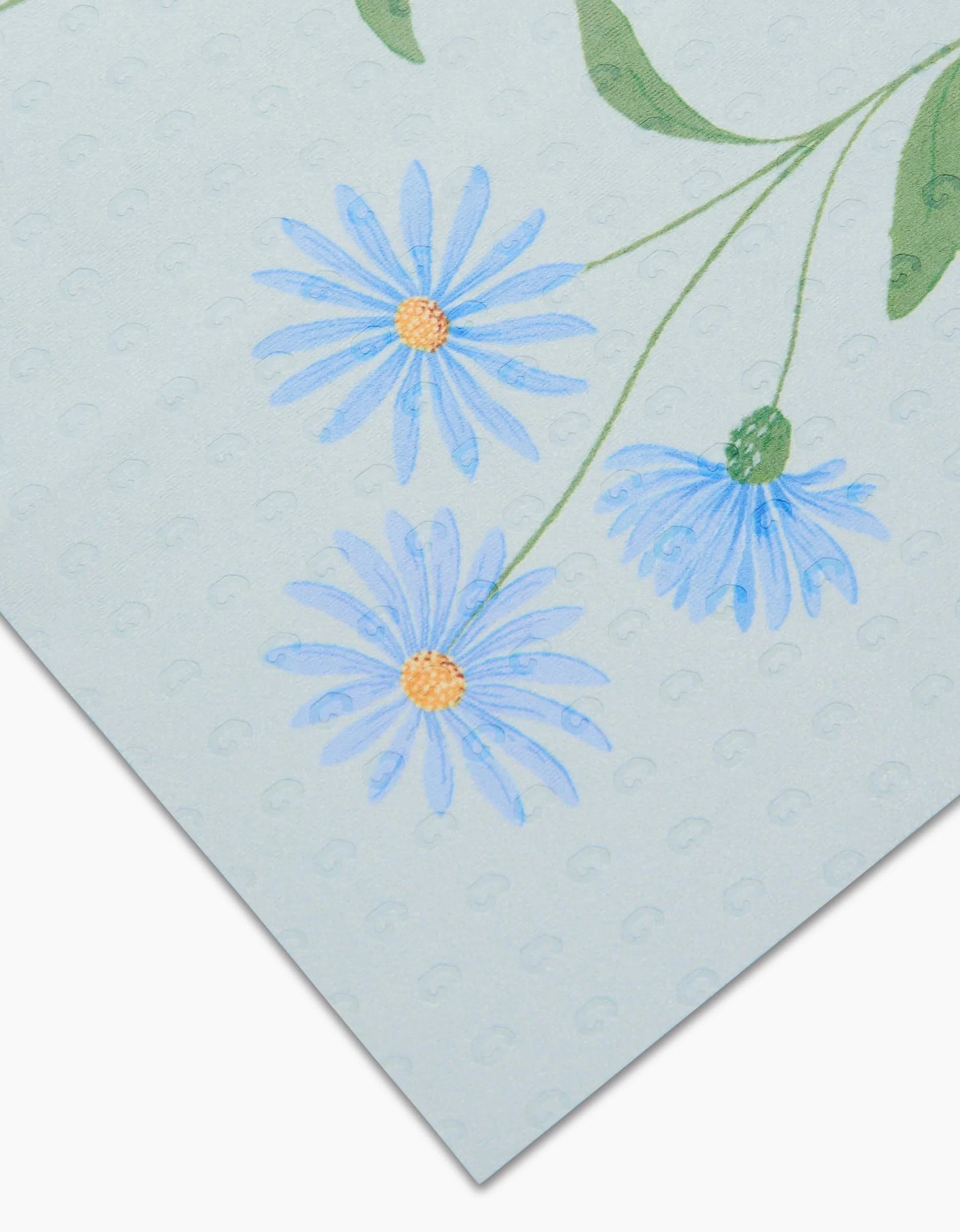 September Aster by Linda Fox is a light blue paper with an embossed dot pattern and a printed trio of blue, daisy-like flowers with yellow centers in one corner. Made from eco-friendly, post-consumer recycled materials.