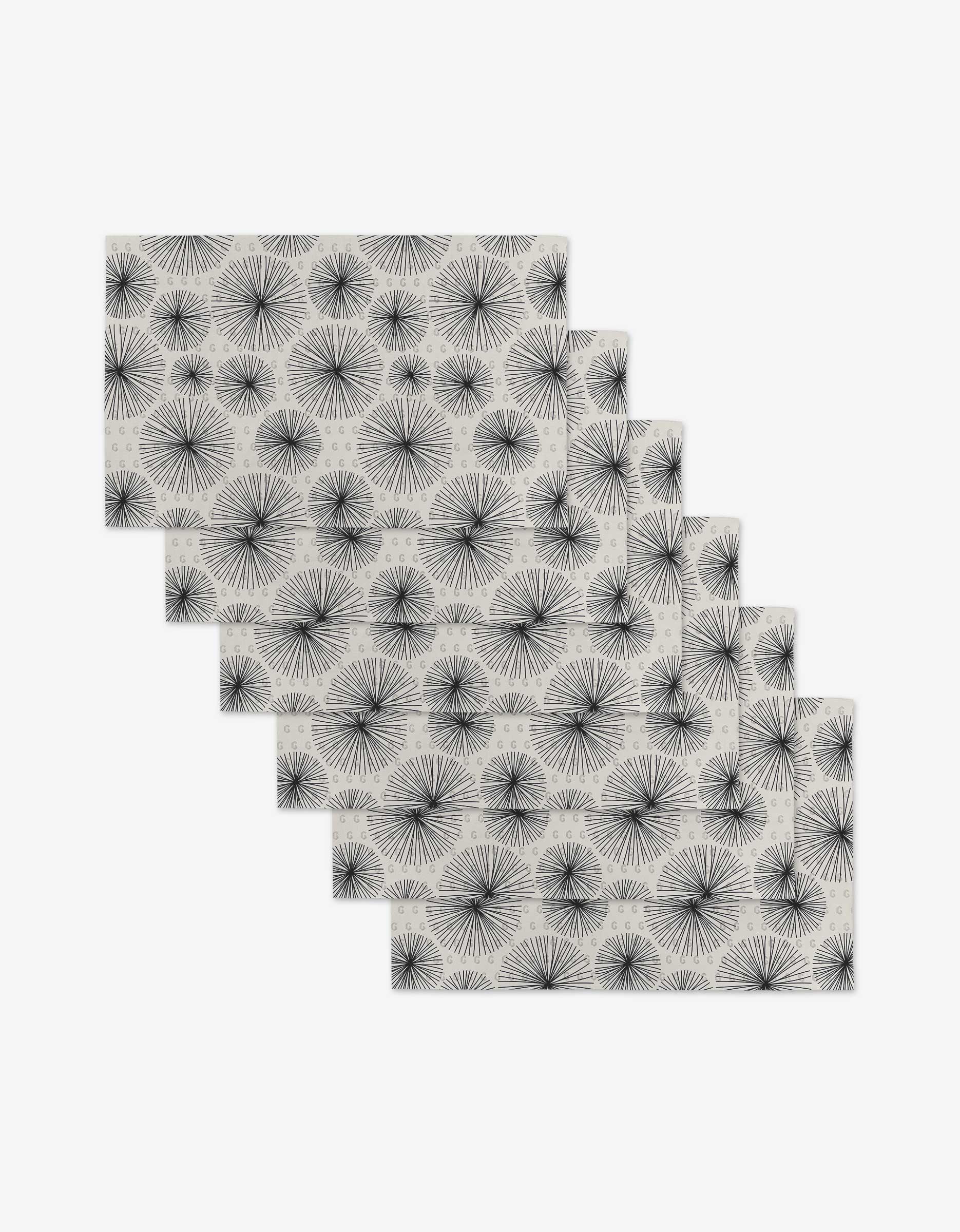 Sky Party by GEOMETRY: Six rectangular placemats featuring a repeating black dandelion seed pattern on white, made from recycled materials—an eco-friendly alternative to paper towels.